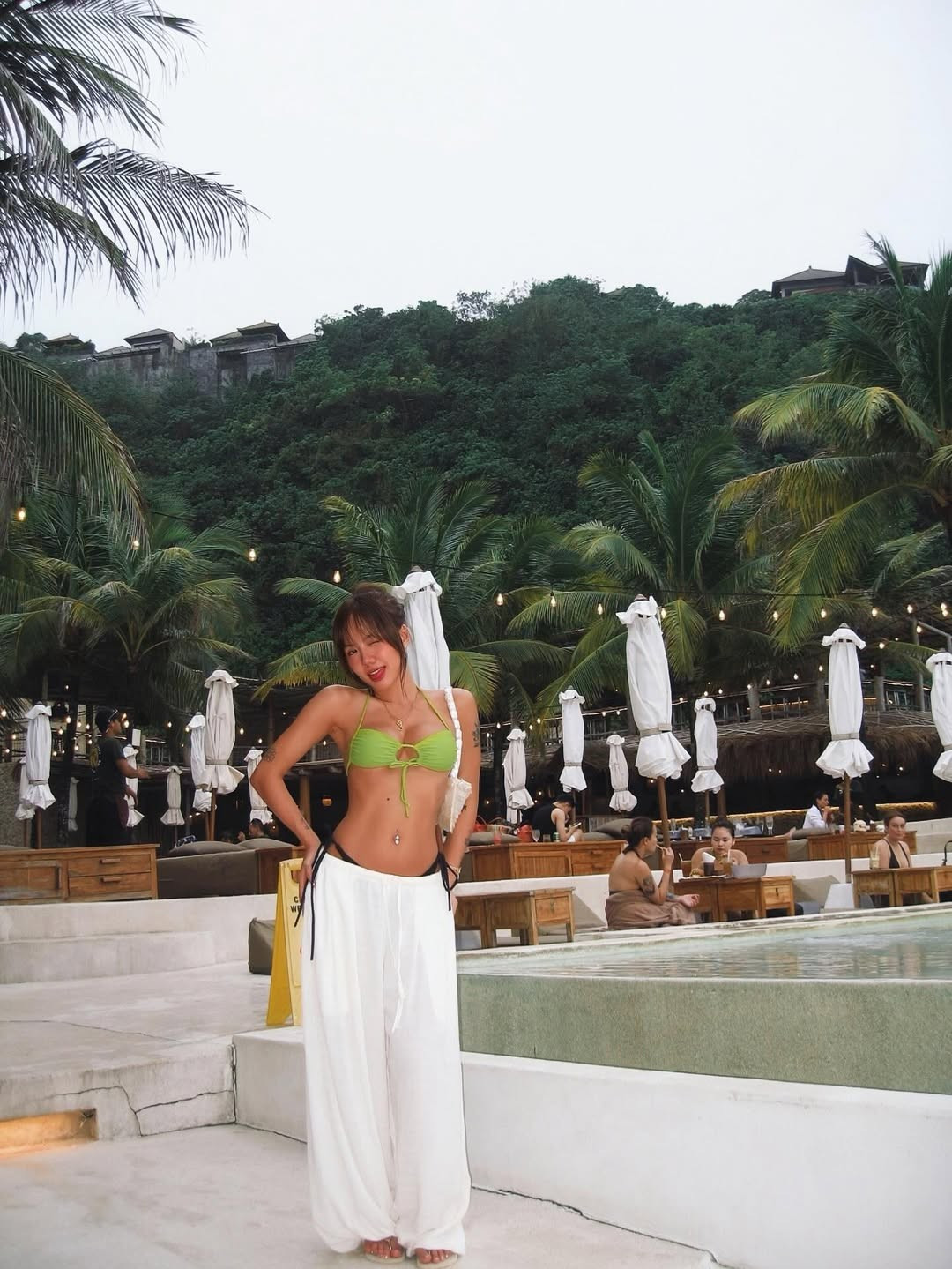 Điểm xuyết cho bộ trang phục là chiếc khuyên rốn lấp lánh và các lớp vòng cổ layer tinh tế. Đặc biệt, người hâm mộ còn soi được những món đồ hiệu như túi xách nhỏ và kính mát sành điệu. (Ảnh: IGNV)