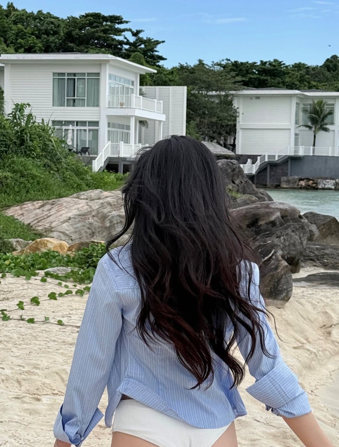 Trong bộ ảnh, Mina Young lựa chọn thiết kế bikini hai mảnh tông trắng tinh khôi, kết hợp khéo léo cùng chiếc áo sơ mi xanh kẻ sọc khoác ngoài hờ hững. (Ảnh: IGNV)