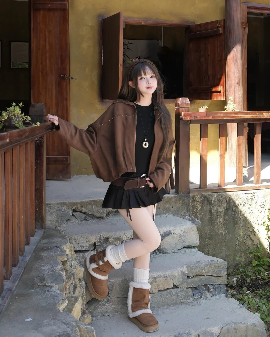 Cô nàng diện chiếc áo khoác lửng màu nâu đất với chi tiết đinh tán nhẹ nhàng, vừa giữ ấm vừa tôn lên vòng eo thon gọn, kết hợp cùng chân váy ngắn đen, quần tất trắng. (Ảnh: IGNV)