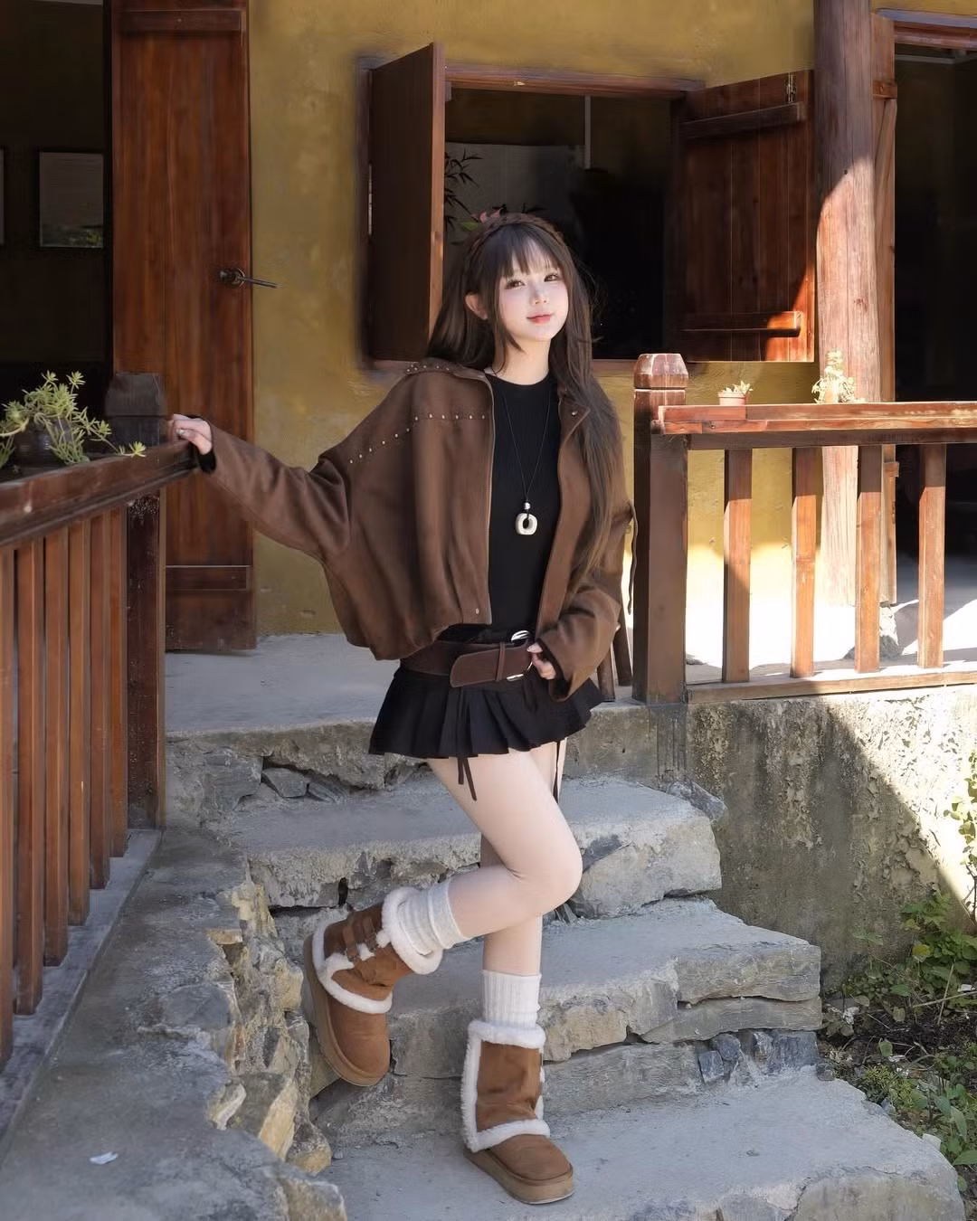 Cô nàng diện chiếc áo khoác lửng màu nâu đất với chi tiết đinh tán nhẹ nhàng, vừa giữ ấm vừa tôn lên vòng eo thon gọn, kết hợp cùng chân váy ngắn đen, quần tất trắng. (Ảnh: IGNV)