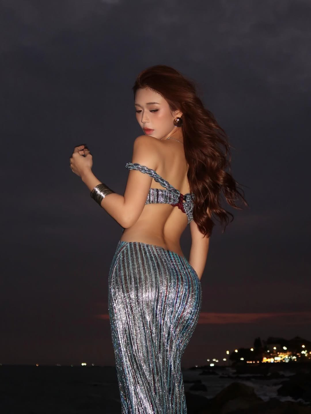 Kết hợp cùng khung cảnh biển đêm với những con sóng nhẹ và ánh đèn xa xa, bộ ảnh mang đến một bầu không khí vừa lãng mạn, vừa bí ẩn, khẳng định gu thời trang độc đáo và sự táo bạo của hot girl sinh năm 2002. (Ảnh: IGNV)