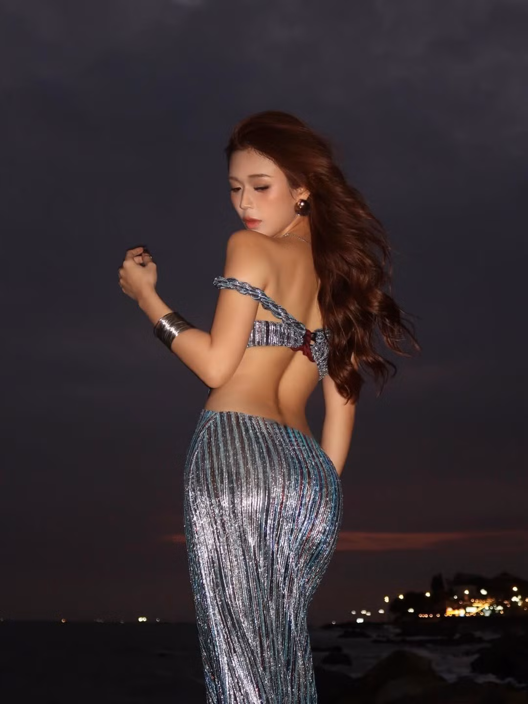 Kết hợp cùng khung cảnh biển đêm với những con sóng nhẹ và ánh đèn xa xa, bộ ảnh mang đến một bầu không khí vừa lãng mạn, vừa bí ẩn, khẳng định gu thời trang độc đáo và sự táo bạo của hot girl sinh năm 2002. (Ảnh: IGNV)