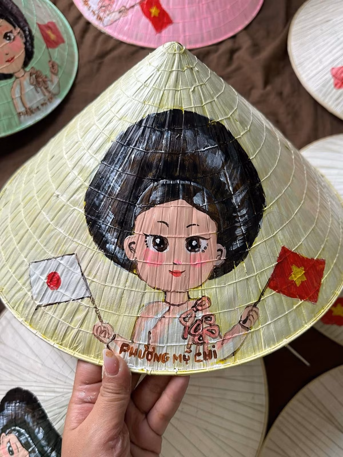 Cô viết: "Đây là chút tâm ý nhỏ dành tặng cho các bạn quốc tế. Nón lá được vẽ tay trực tiếp hình ảnh của Chi, quốc kỳ Việt Nam và quốc kỳ của nước bạn". Phương Mỹ Chi hy vọng mỗi chiếc nón sẽ là một kỷ niệm đẹp về Việt Nam trong lòng bạn bè quốc tế.