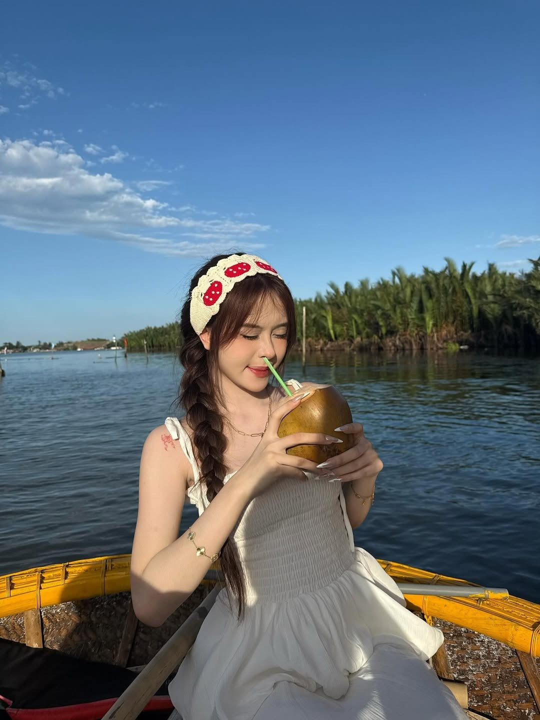 Điểm nhấn là chiếc băng đô cài tóc với họa tiết quả dâu tây dễ thương, cùng mái tóc tết lệch một bên, tạo nên một tổng thể vừa dịu dàng, vừa cá tính.