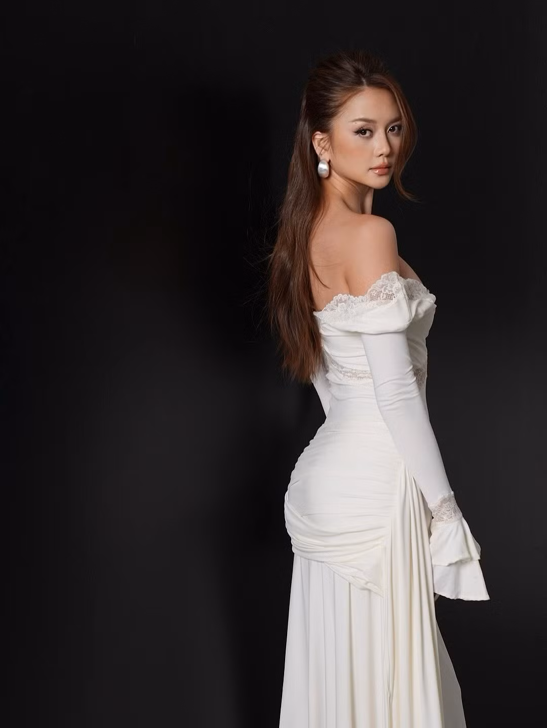 Phần ống dài với chi tiết bèo nhún ở cổ tay tạo sự bay bổng, mềm mại và nữ tính. Dải lụa váy kéo dài từ eo, đổ xuống mặt sàn tạo cảm giác thướt tha, khiến mỗi bức ảnh như một tác phẩm nghệ thuật. (Ảnh: IGNV)