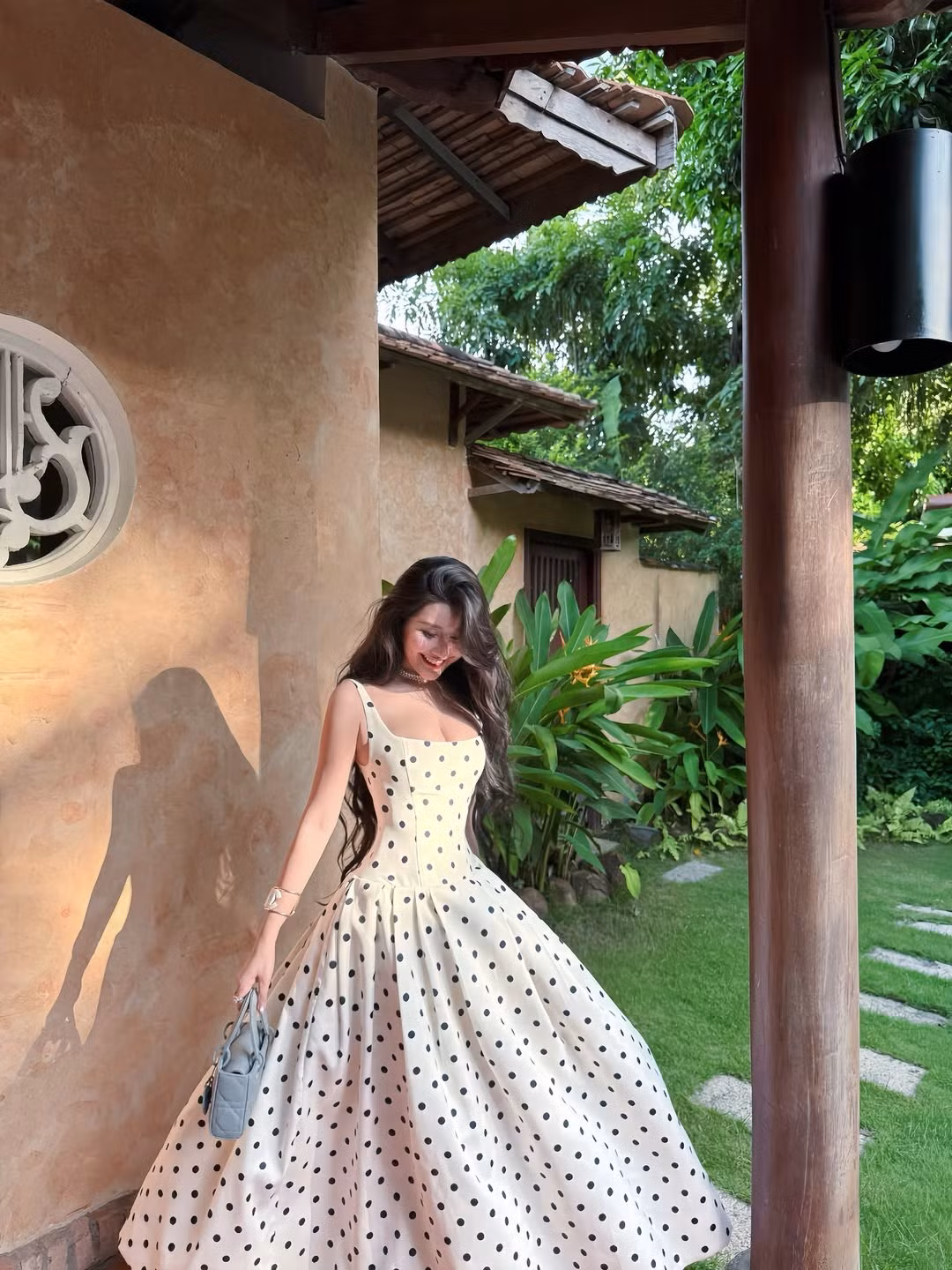 Đặc biệt, là một trong những họa tiết không bao giờ lỗi mốt, chấm bi mang lại sự trẻ trung, nổi bật và có chút hoài cổ, rất hợp với không gian kiến trúc truyền thống, nhiều cây xanh mà cô nàng lựa chọn. (Ảnh: IGNV)