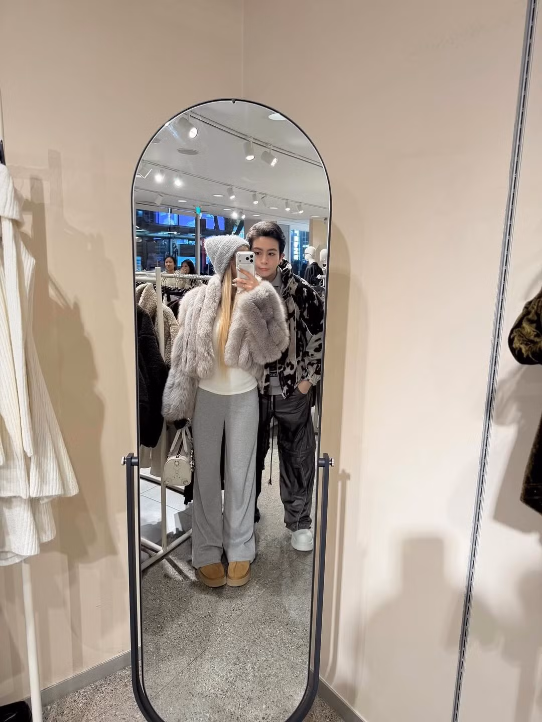 Cặp đôi thể hiện sự gắn kết qua phong cách thời trang đồng điệu. Xoài Non diện những item ấm áp, tôn dáng như áo len trắng xù lông, quần jogger xám ống rộng và mũ len lông xù thời thượng. (Ảnh: IGNV)