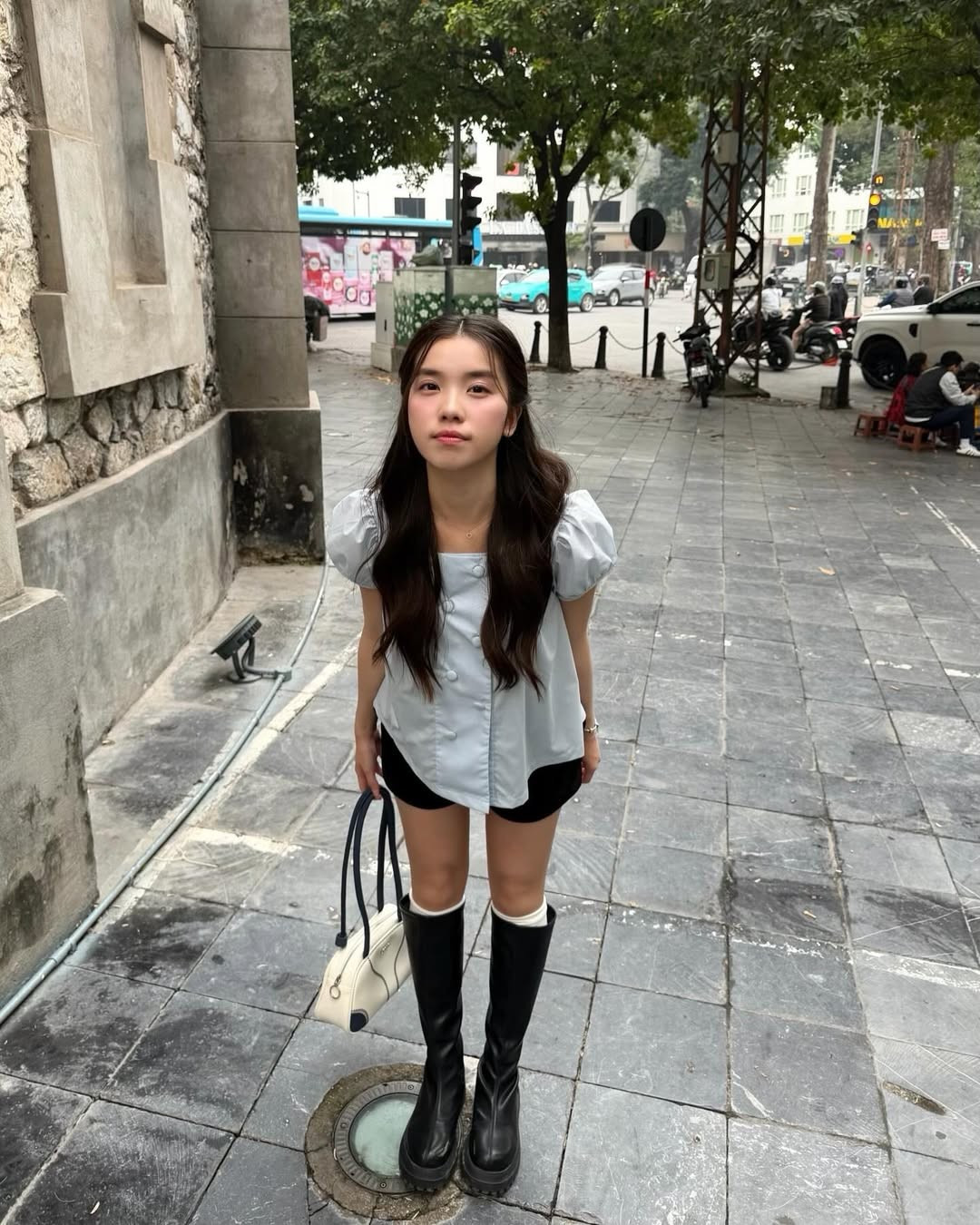 Điểm thú vị trong set đồ của Hà Vi chính là sự kết hợp đối lập giữa phần trên "bánh bèo" và phần dưới cực ngầu. Cô nàng khéo léo phối áo cùng quần short đen basic, đặc biệt là đôi boots cổ cao màu đen mạnh mẽ. (Ảnh: IGNV)