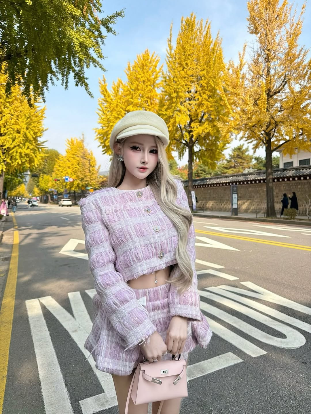 Bộ ảnh được chụp tại một con phố cổ kính, với tường đá truyền thống và hàng cây vàng óng, tạo nên một bức tranh hoàn hảo cho phong cách thời trang của người đẹp gốc Nha Trang. (Ảnh: IGNV)