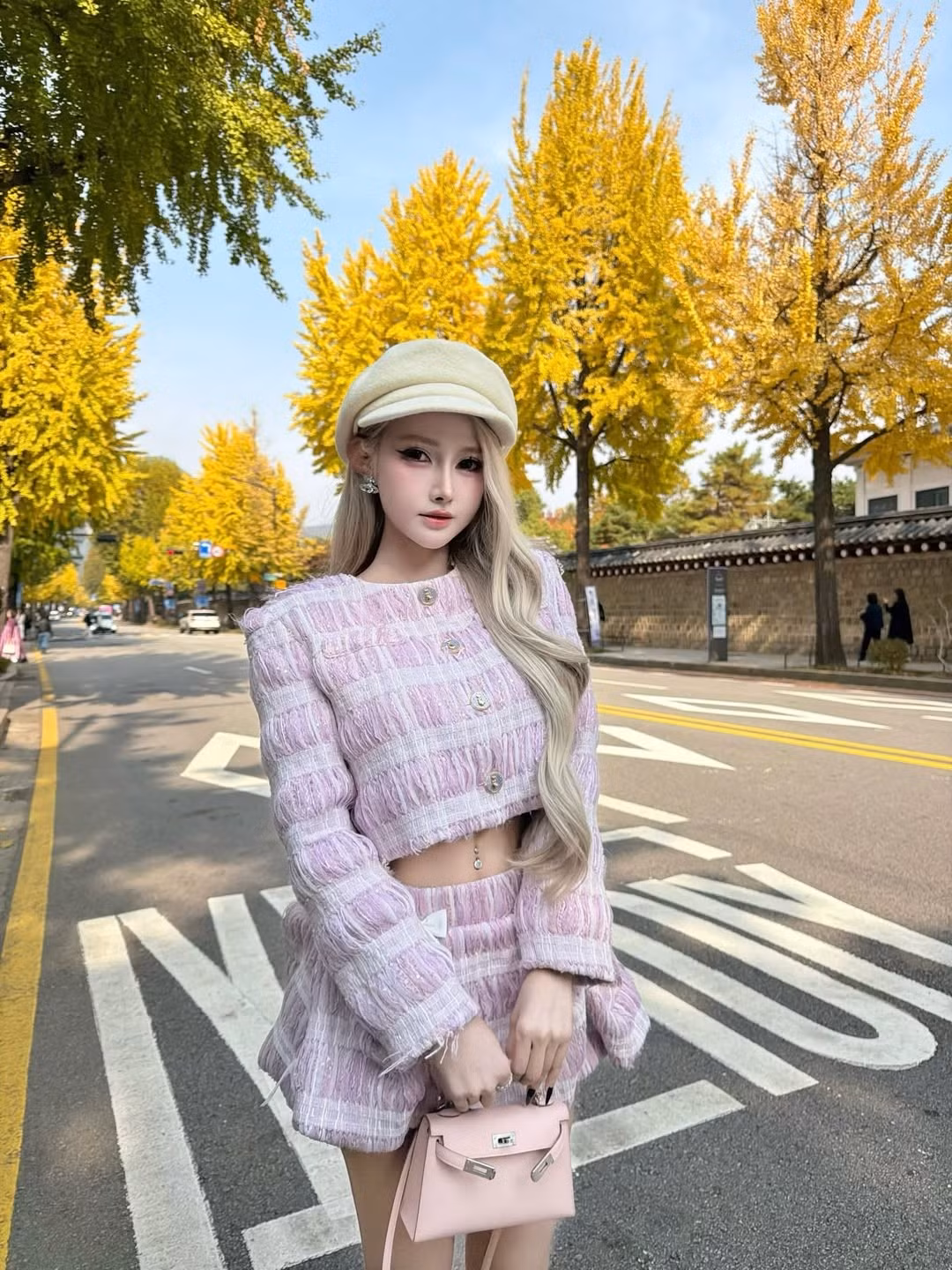 Bộ ảnh được chụp tại một con phố cổ kính, với tường đá truyền thống và hàng cây vàng óng, tạo nên một bức tranh hoàn hảo cho phong cách thời trang của người đẹp gốc Nha Trang. (Ảnh: IGNV)