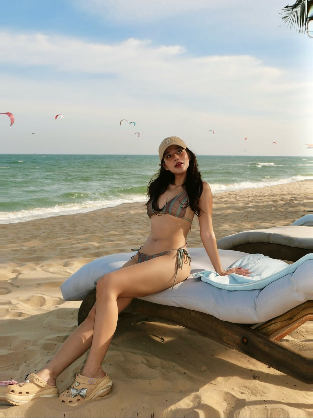 Cô nàng cũng không ngần ngại tạo dáng đa dạng, từ việc tạo dáng chụp ảnh bên chiếc máy ảnh phim cổ điển, đến khoảnh khắc thư giãn trên ghế dài tắm nắng hay ngồi trên bãi cát trắng. (Ảnh: IGNV)