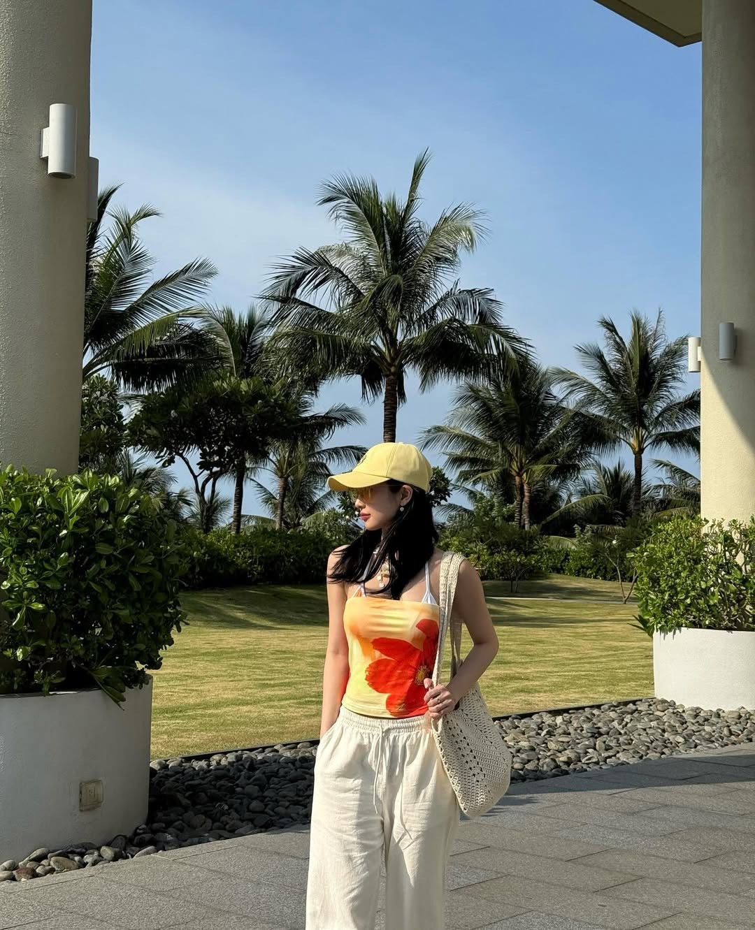 Trong loạt ảnh được đăng tải, Jun Vũ diện một chiếc áo hai dây họa tiết cam-vàng rực rỡ, kết hợp cùng quần ống rộng màu be và dép tông đơn giản. (Ảnh: IGNV)