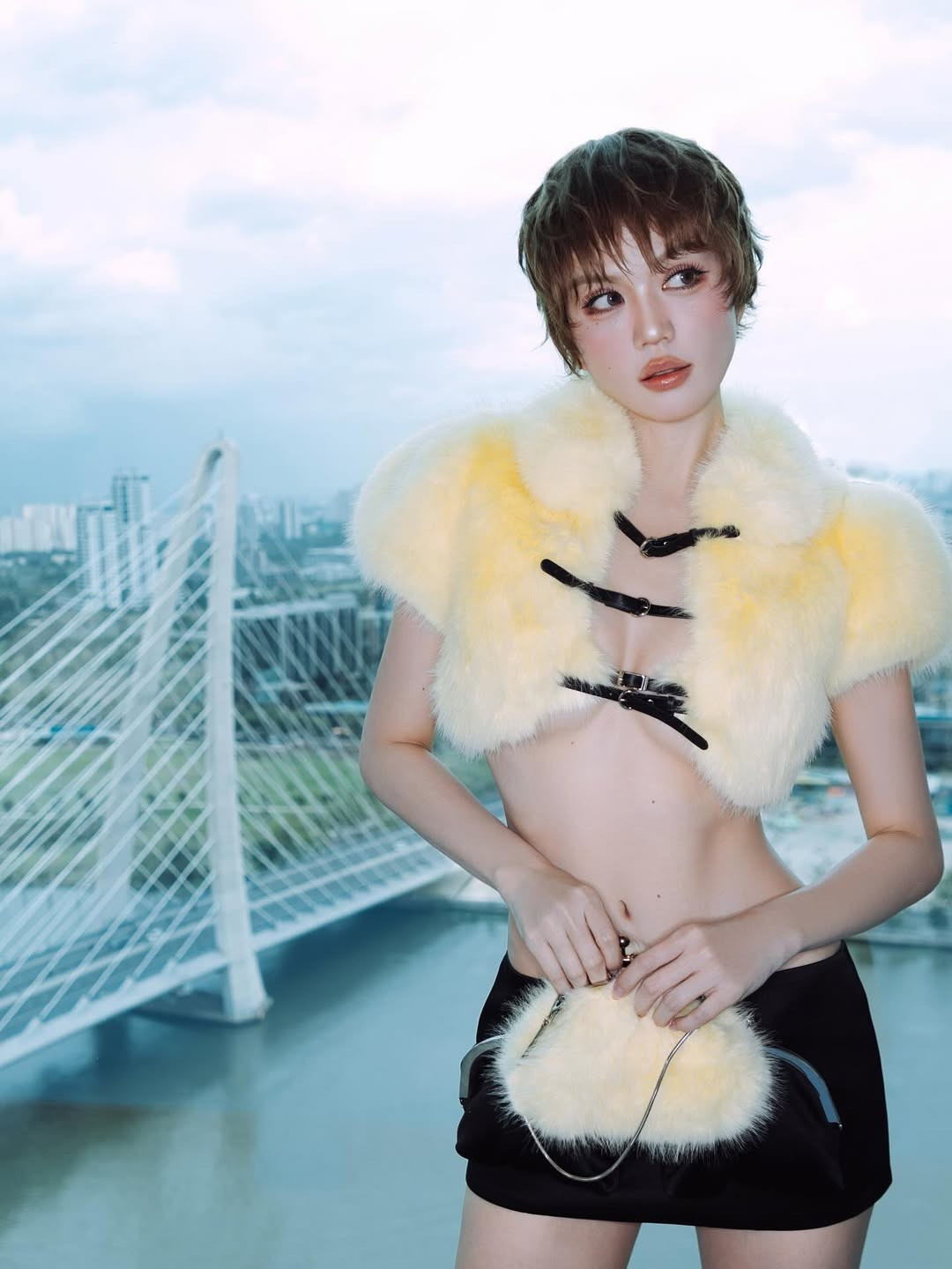 Nữ người mẫu phối outfit cùng với chiếc túi lông vàng đồng điệu, khiến tổng thể thêm thời thượng.