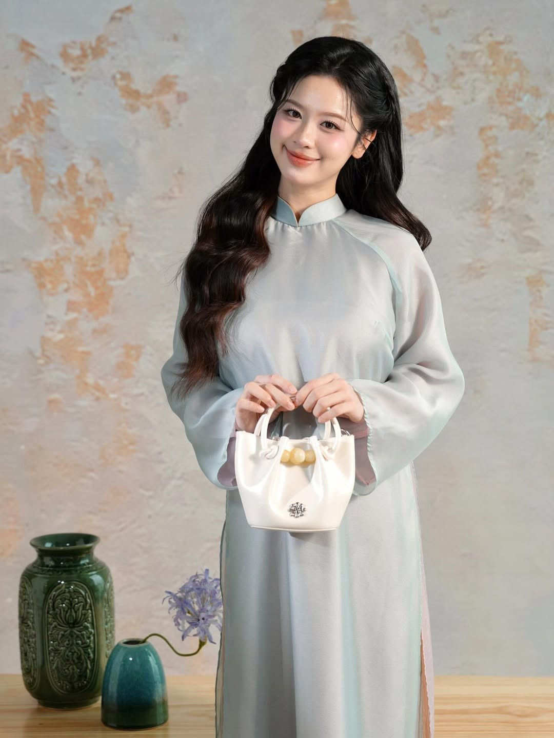 Để hoàn thiện layout đón Tết, Hàn Hằng khéo léo kết hợp cùng mẫu túi xách mini cầm tay màu hồng phấn và trắng kem. Chi tiết hạt ngọc trang trí trên túi không chỉ tạo điểm nhấn sang trọng mà còn rất phù hợp với tinh thần của ngày Tết cổ truyền. (Ảnh: IGNV)