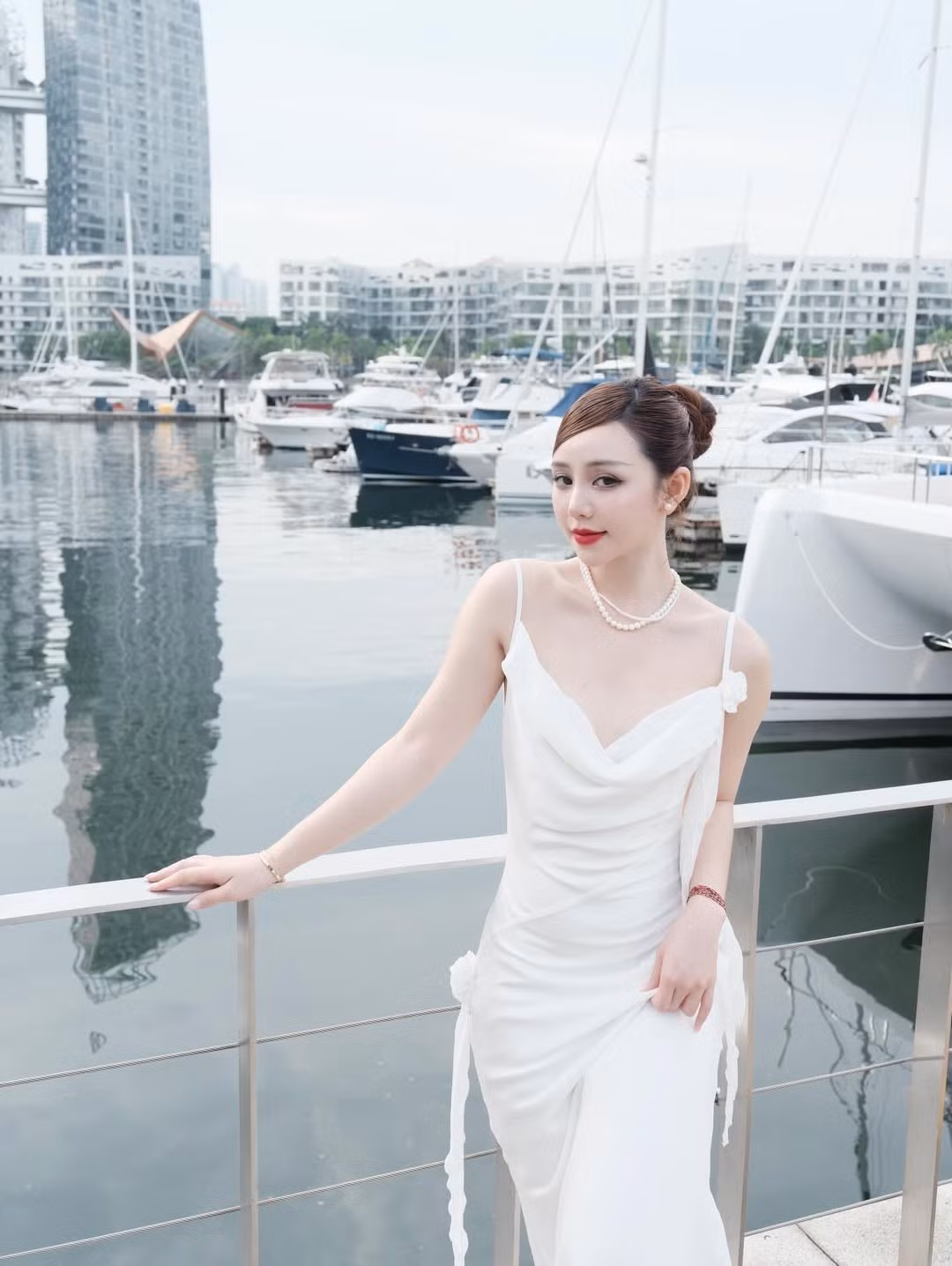 Sự đơn giản nhưng gợi cảm của chiếc váy được nâng tầm bởi phụ kiện ngọc trai quý phái, từ vòng cổ cho đến chi tiết trang trí tinh tế trên túi xách, tạo nên tổng thể vừa cổ điển, vừa hiện đại. (Ảnh: IGNV)