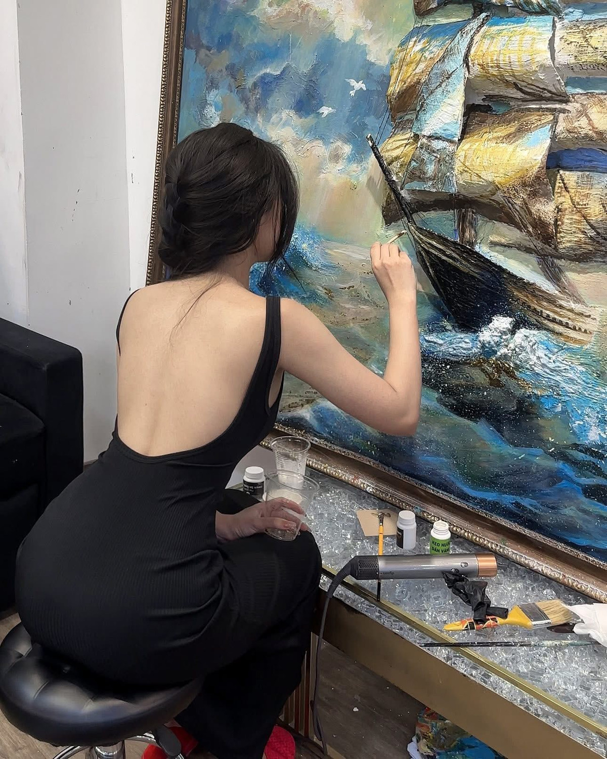 Hình ảnh nữ họa sĩ cầm cọ vẽ một cách nghiêm túc trong bộ áo mưa đã khiến cộng đồng mạng được một phen "dở khóc dở cười". (Ảnh: FBNV)