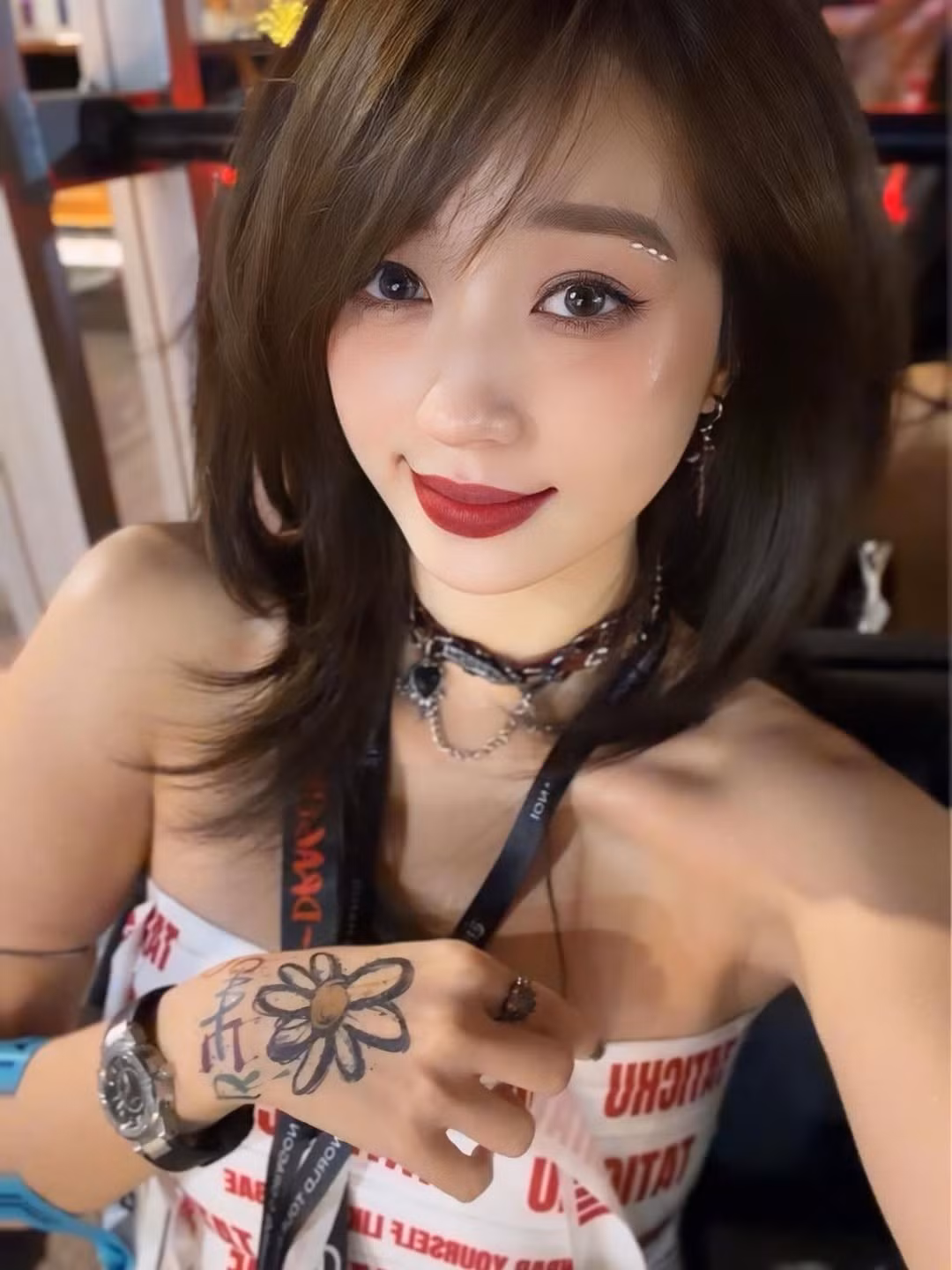 Cô nàng diện một chiếc crop top cúp ngực màu trắng với họa tiết chữ in graphic cá tính. Trang phục được phối cùng quần short da bóng màu nâu đỏ và tất đùi trắng, tạo nên tổng thể vừa sexy vừa có chút hoài niệm Y2K pha lẫn Punk-Rock. (Ảnh: IGNV)