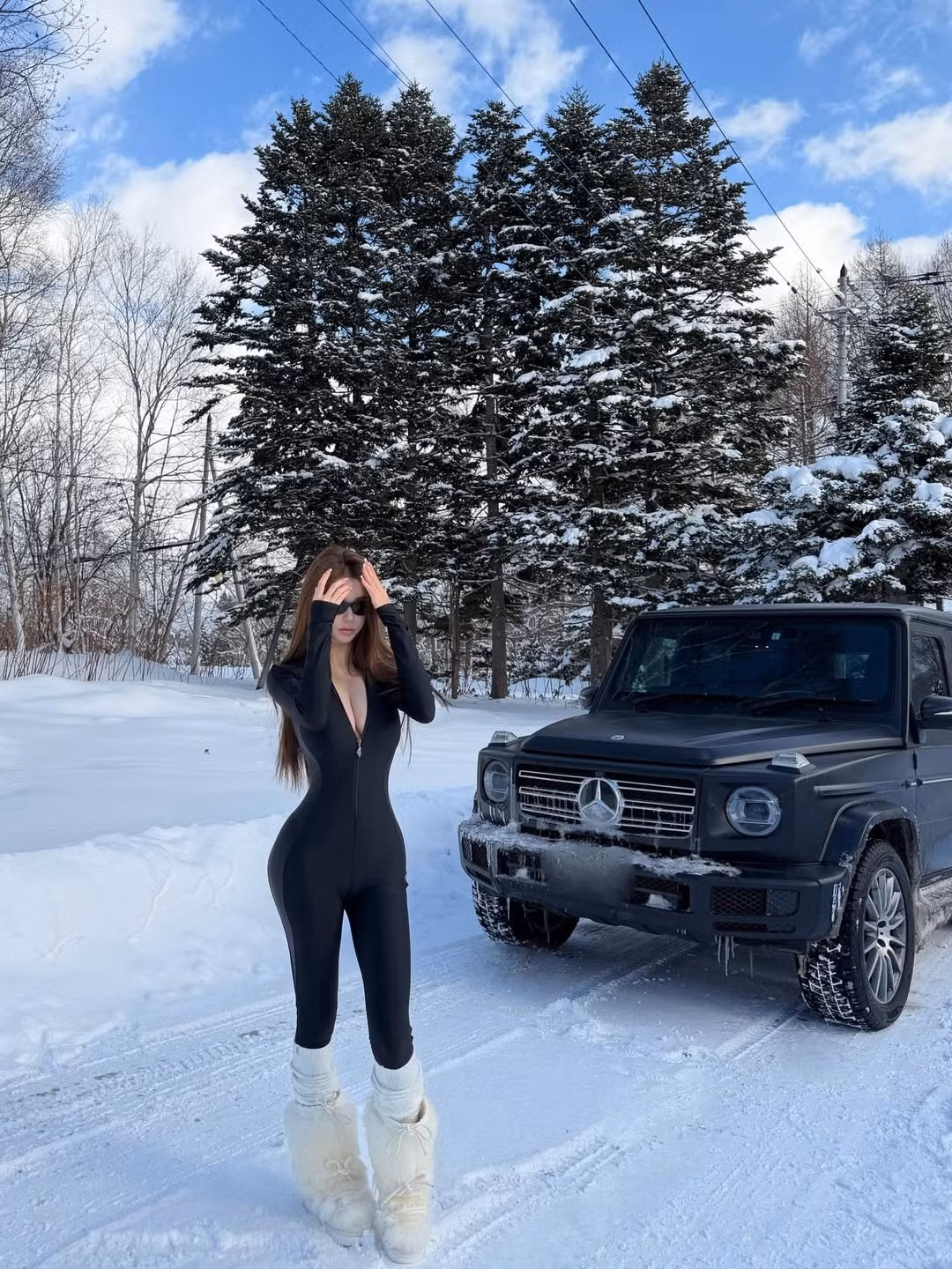 Theo đó, cô gái diện bộ đồ bó sát màu đen huyền bí, đối lập hoàn toàn với màu trắng của tuyết và màu đen nhám của chiếc "vua địa hình" G-Wagon. (Ảnh: IGNV)