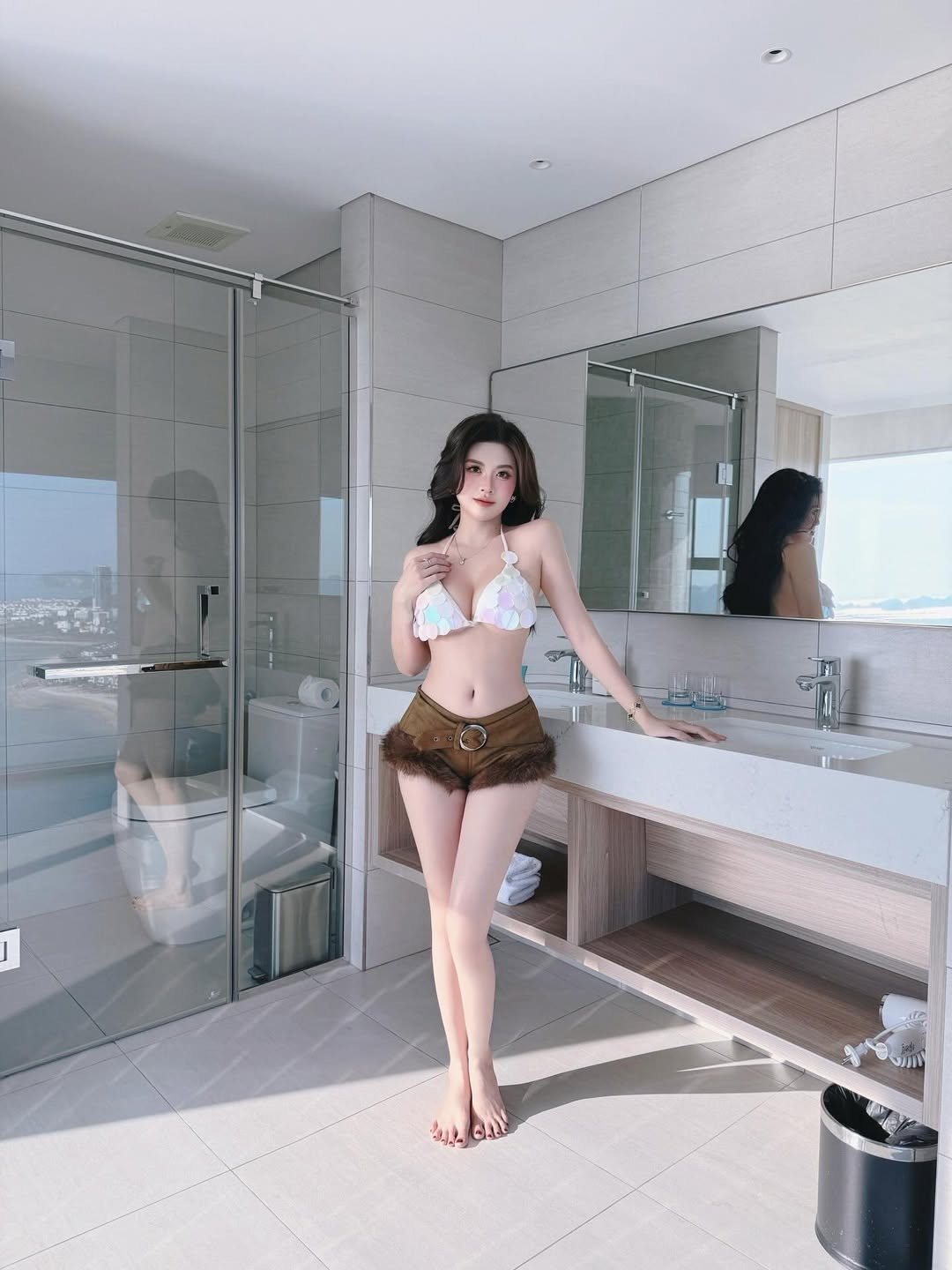 Trong bộ ảnh mới nhất, Huyền Trang xuất hiện trong không gian sang trọng của một resort. Cô lựa chọn thiết kế bikini phối hợp độc đáo giữa phần áo đính kim sa lấp lánh và quần short chất liệu da lộn viền lông. (Ảnh: IGNV)