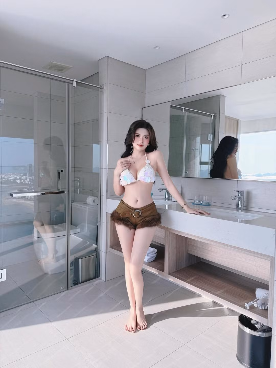 Trong bộ ảnh mới nhất, Huyền Trang xuất hiện trong không gian sang trọng của một resort. Cô lựa chọn thiết kế bikini phối hợp độc đáo giữa phần áo đính kim sa lấp lánh và quần short chất liệu da lộn viền lông. (Ảnh: IGNV)