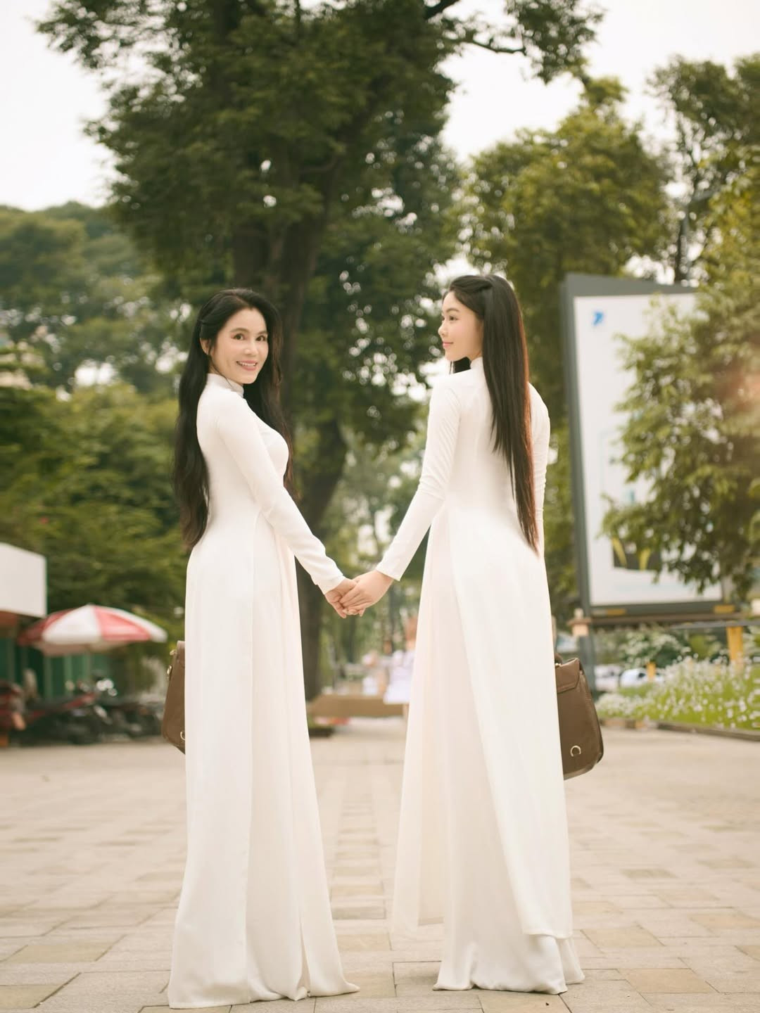 Lọ Lem đứng bên mẹ - doanh nhân Dạ Thảo, cả hai cùng diện áo dài trắng tinh khôi, tạo nên khung cảnh nhẹ nhàng và đầy cảm xúc. (Ảnh: IGNV)