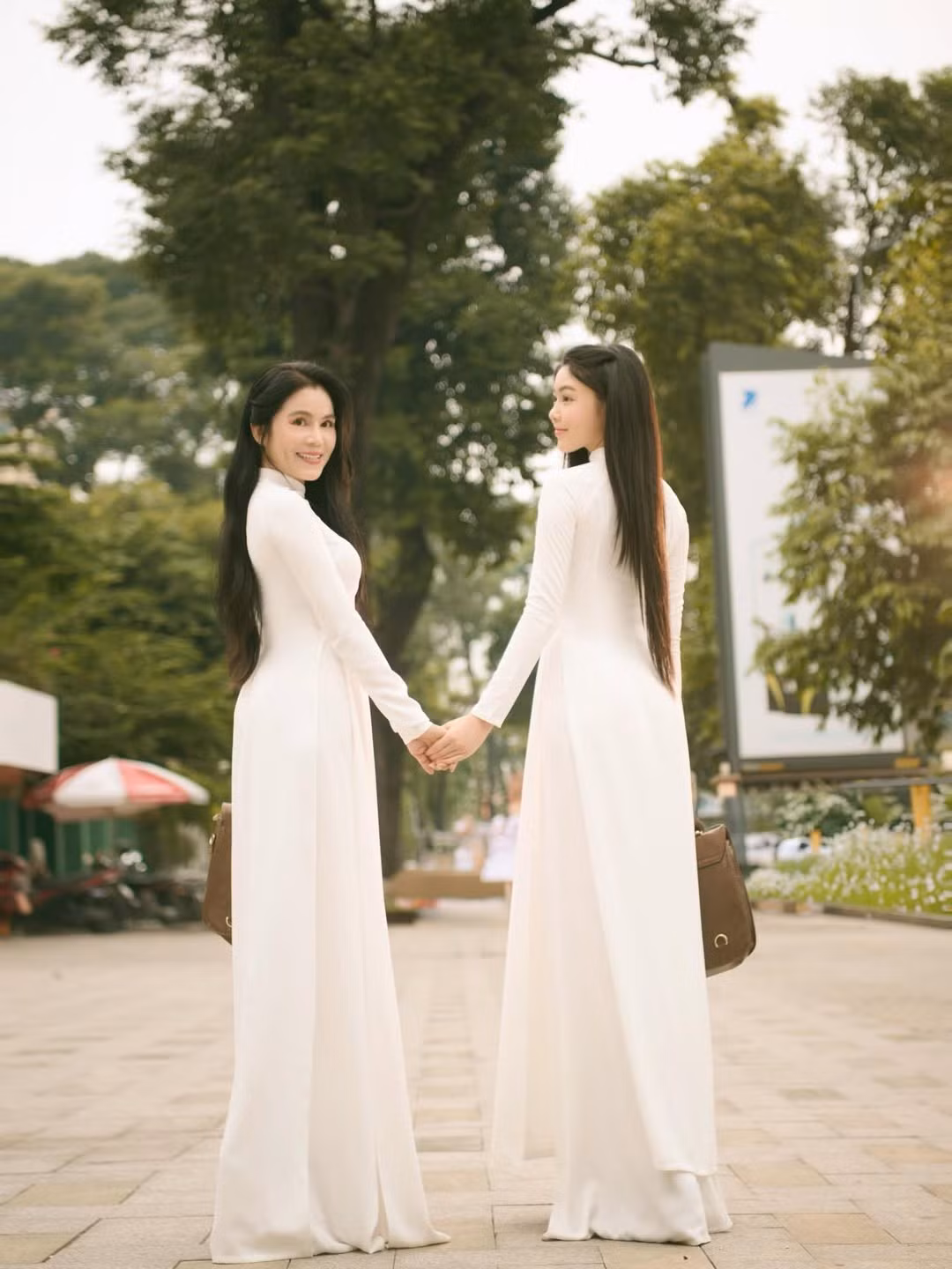 Lọ Lem đứng bên mẹ - doanh nhân Dạ Thảo, cả hai cùng diện áo dài trắng tinh khôi, tạo nên khung cảnh nhẹ nhàng và đầy cảm xúc. (Ảnh: IGNV)