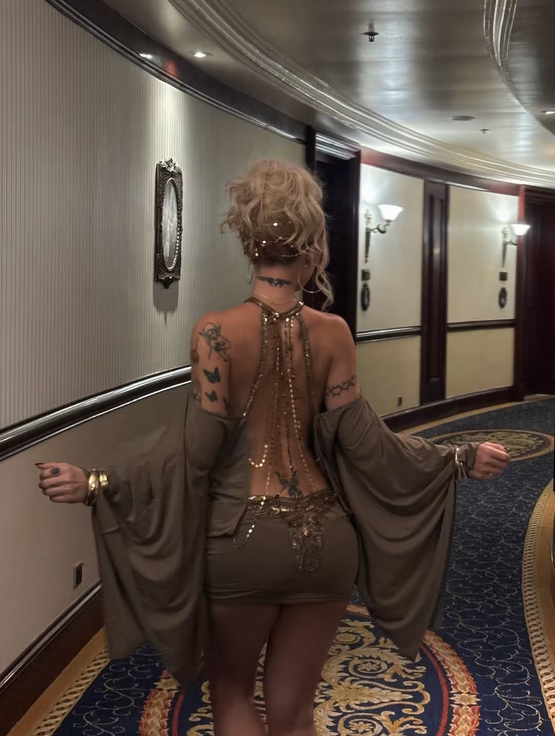 Chiếc váy với phần lưng hở giúp cô nàng khoe những hình xăm nghệ thuật đầy cá tính, tăng thêm vẻ "nghệ" và nổi loạn, hài hòa một cách bất ngờ với trang phục quyến rũ. (Ảnh: IGNV)