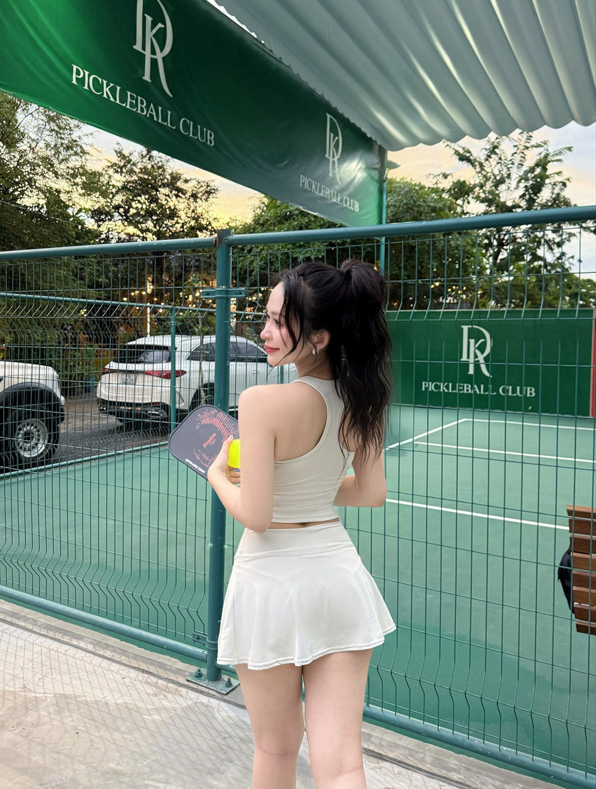 Uyên Trần lựa chọn một set đồ thể thao tông trắng ngà tối giản nhưng vô cùng tinh tế: áo tank-top ôm sát khoe vòng eo thon gọn cùng chân váy tennis xòe nhẹ giúp tôn đôi chân dài quyến rũ.