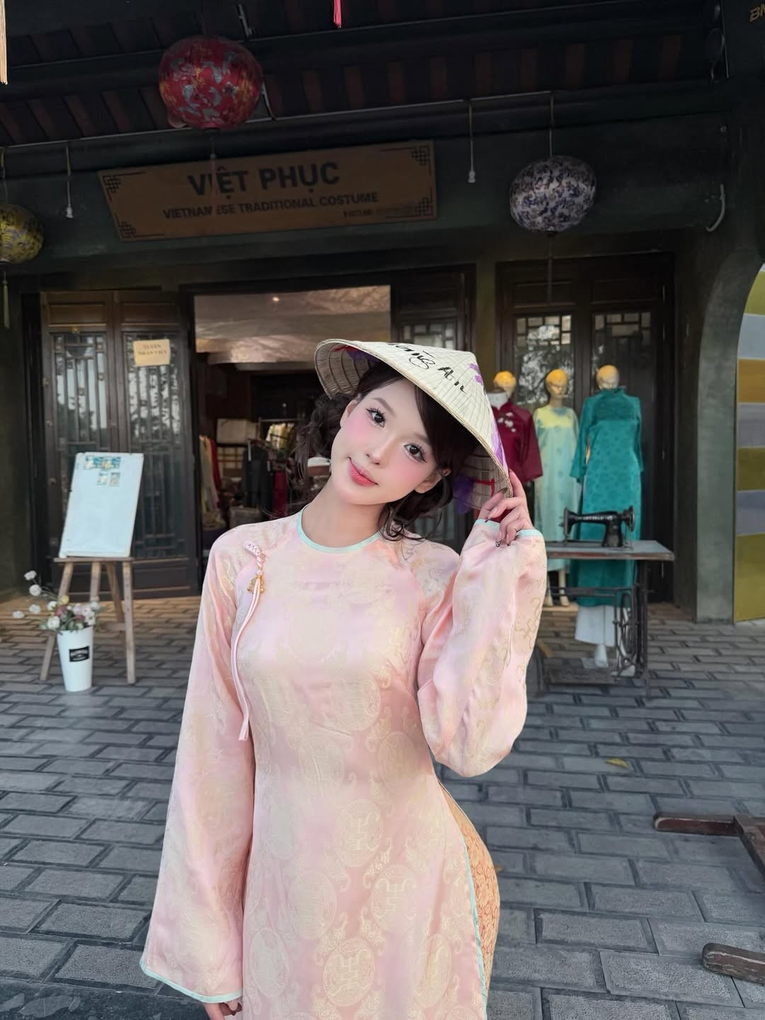 Bên cạnh đó, Wyn Anh còn thư thả trải nghiệm đi thuyền rồng trên sông, hay tạo dáng trước một cửa hàng trong phố cổ với bảng hiệu "Việt Phục". (Ảnh: IGNV)