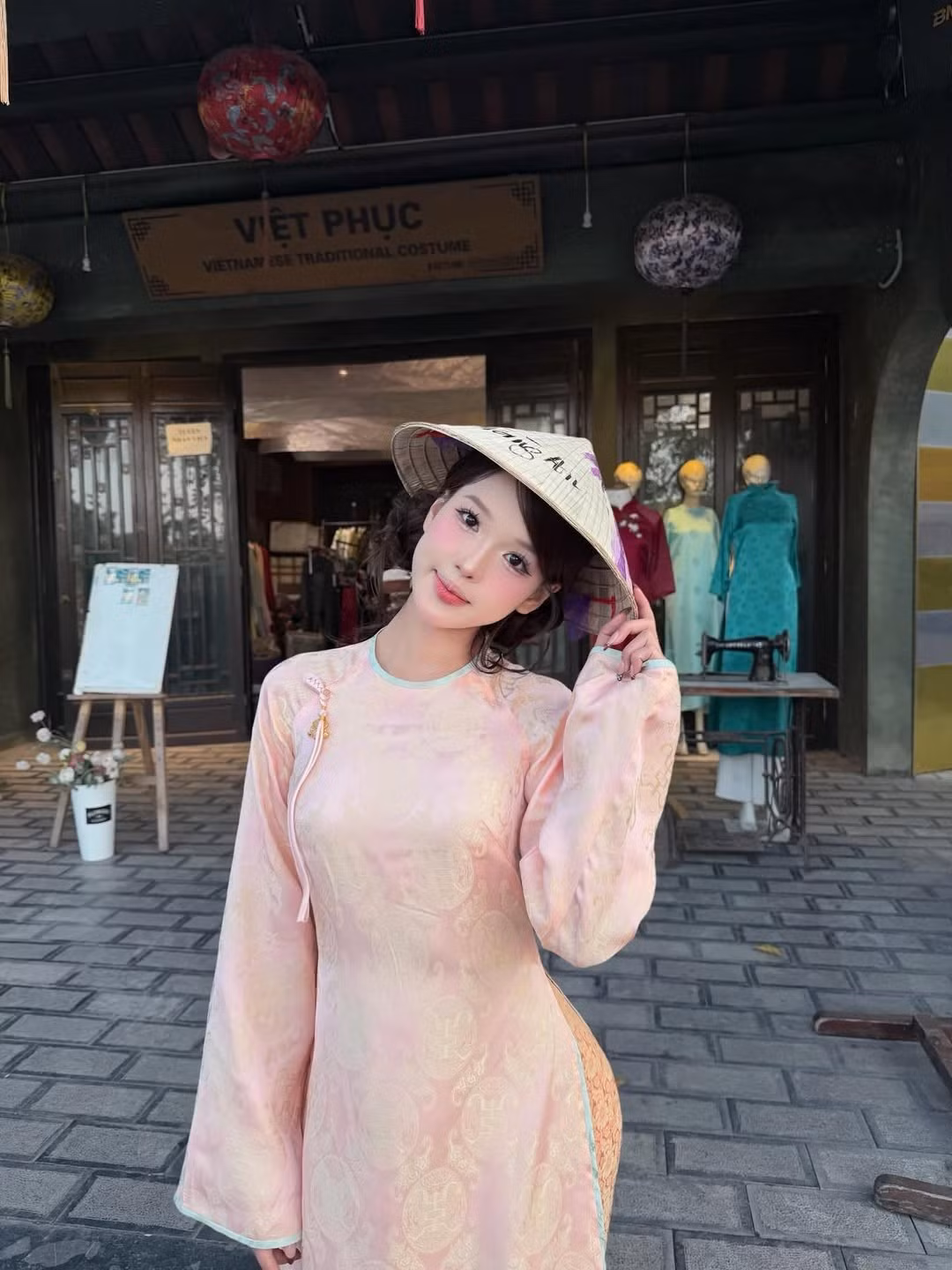 Bên cạnh đó, Wyn Anh còn thư thả trải nghiệm đi thuyền rồng trên sông, hay tạo dáng trước một cửa hàng trong phố cổ với bảng hiệu "Việt Phục". (Ảnh: IGNV)