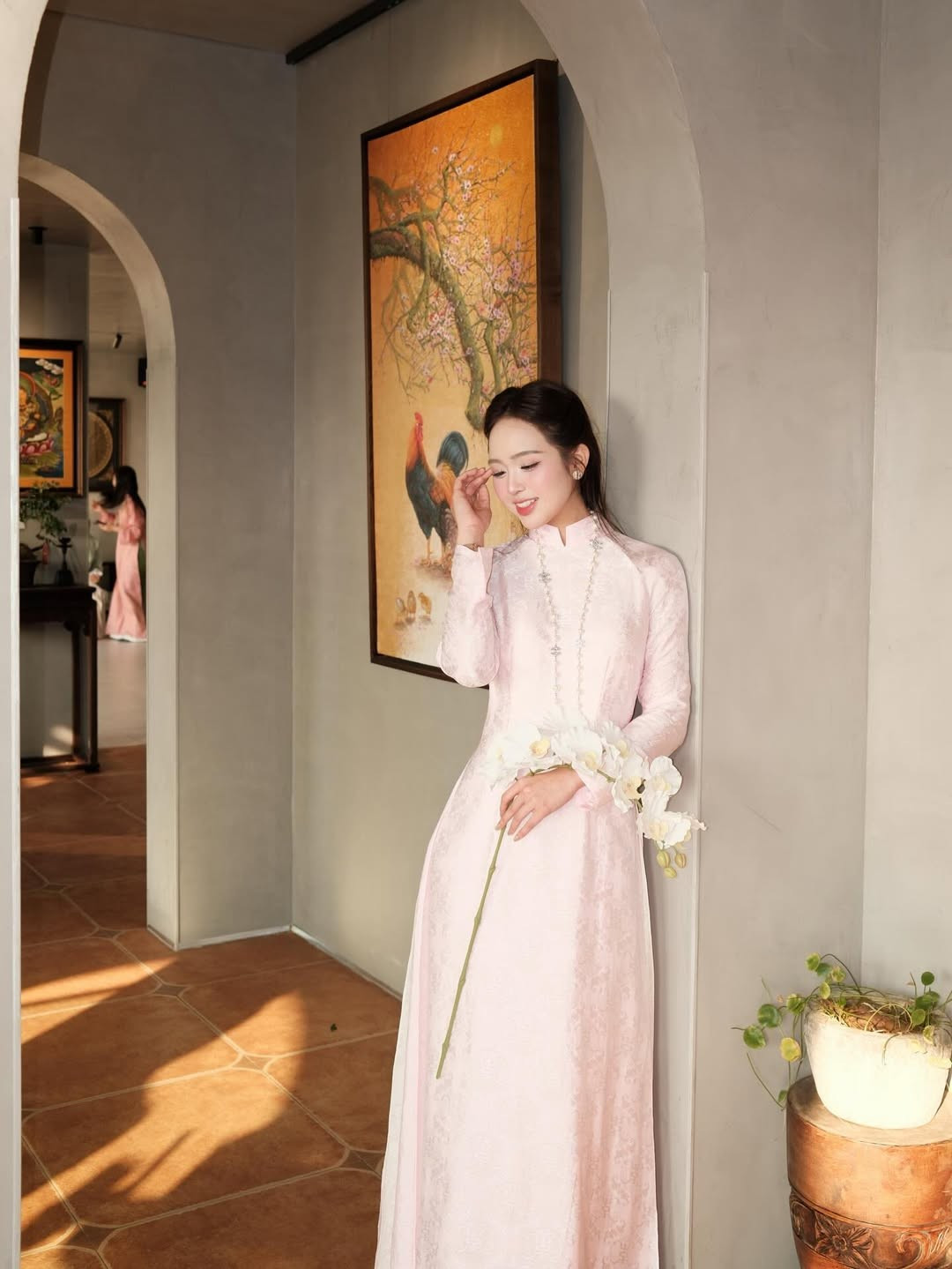 Qua từng khung hình, từ cách ngồi uyển chuyển bên chiếc bàn gỗ cổ đến nụ cười mỉm chi bên nhành hoa lan trắng, cô nàng đã thành công trong việc khắc họa hình ảnh người phụ nữ Việt Nam vừa hiện đại vừa mang đậm cốt cách truyền thống. (Ảnh: IGNV)