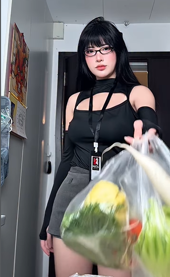 Mở đầu đoạn clip, Una Tố Uyên xuất hiện trong bộ trang phục hiện đại với áo đen cắt xẻ táo bạo kết hợp cùng chân váy ngắn, khoe khéo đôi chân dài miên man. Hình ảnh cô nàng xách túi nguyên liệu tươi ngon bước vào căn bếp hiện đại khiến người đối diện khó rời mắt. (Ảnh: IGNV)