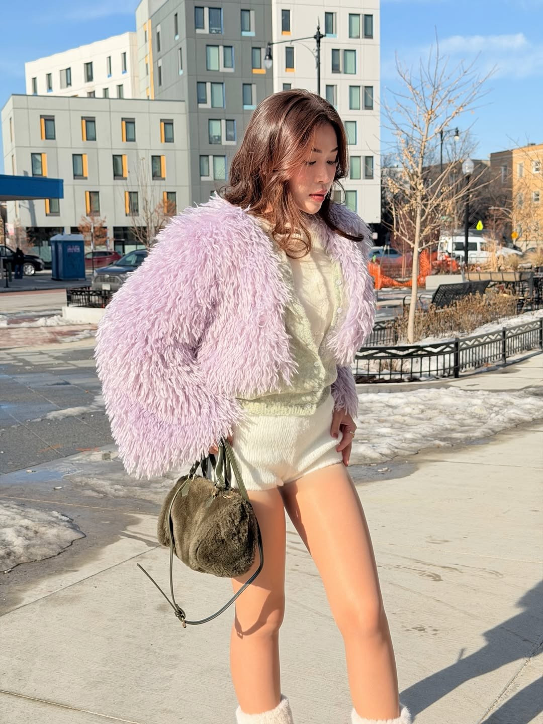 Điểm nhấn chính là chiếc áo khoác lông xù màu tím oải hương cực kỳ nổi bật. Sắc tím nhạt không chỉ mang lại cảm giác ngọt ngào, tiểu thư mà còn tạo hiệu ứng thị giác mạnh mẽ trên nền tuyết trắng. (Ảnh: IGNV)