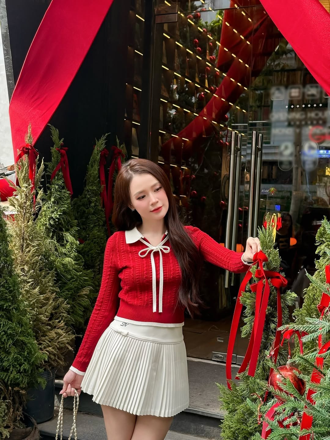 Sam chọn bối cảnh chụp ảnh tại một không gian được trang trí cầu kỳ và ấm cúng, ngập tràn hơi thở Giáng sinh với những cây thông xanh được trang hoàng lộng lẫy bằng quả châu đỏ rực, dây ruy băng và ruy băng đỏ lớn. (Ảnh: IGNV)