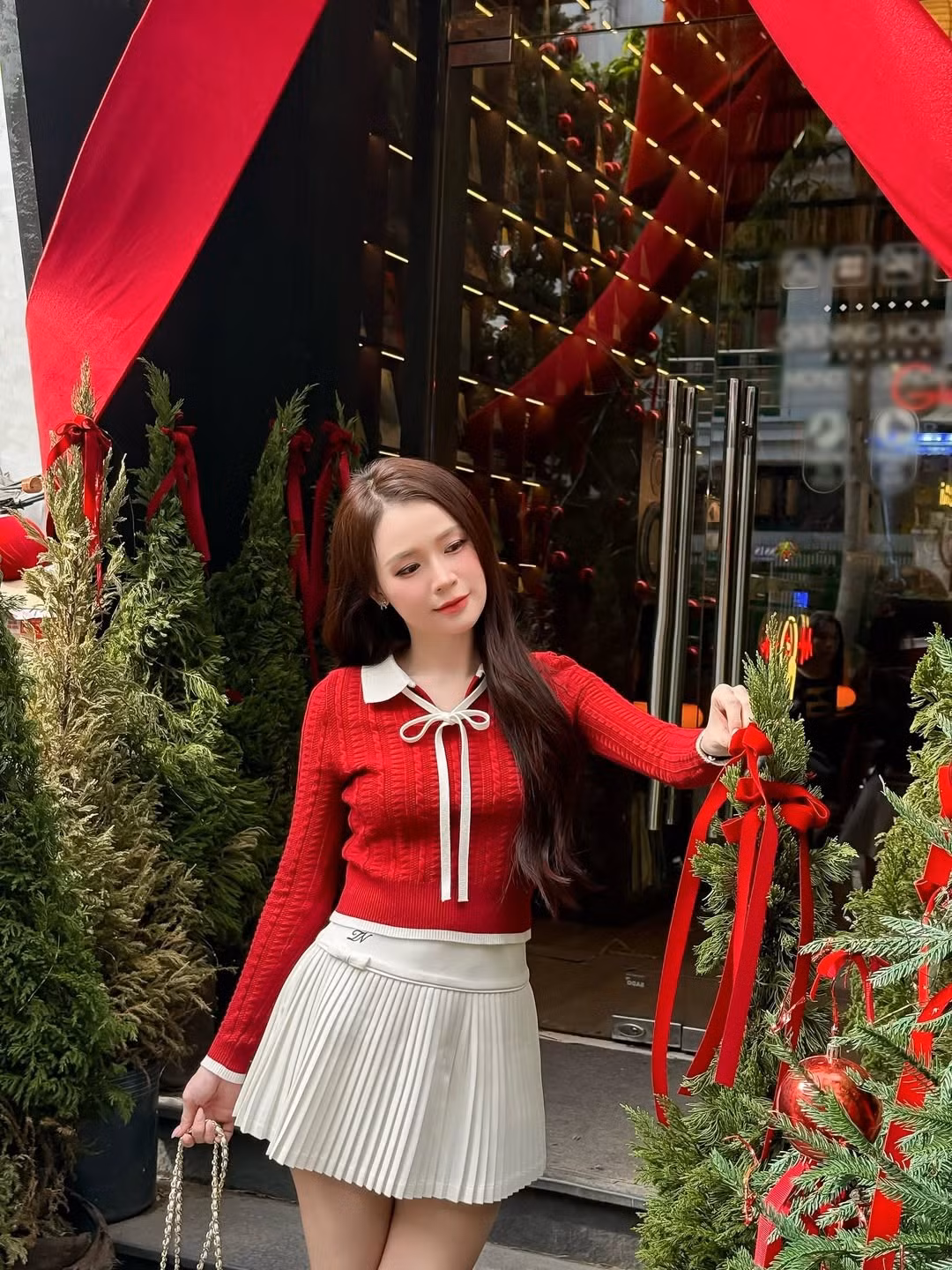 Sam chọn bối cảnh chụp ảnh tại một không gian được trang trí cầu kỳ và ấm cúng, ngập tràn hơi thở Giáng sinh với những cây thông xanh được trang hoàng lộng lẫy bằng quả châu đỏ rực, dây ruy băng và ruy băng đỏ lớn. (Ảnh: IGNV)