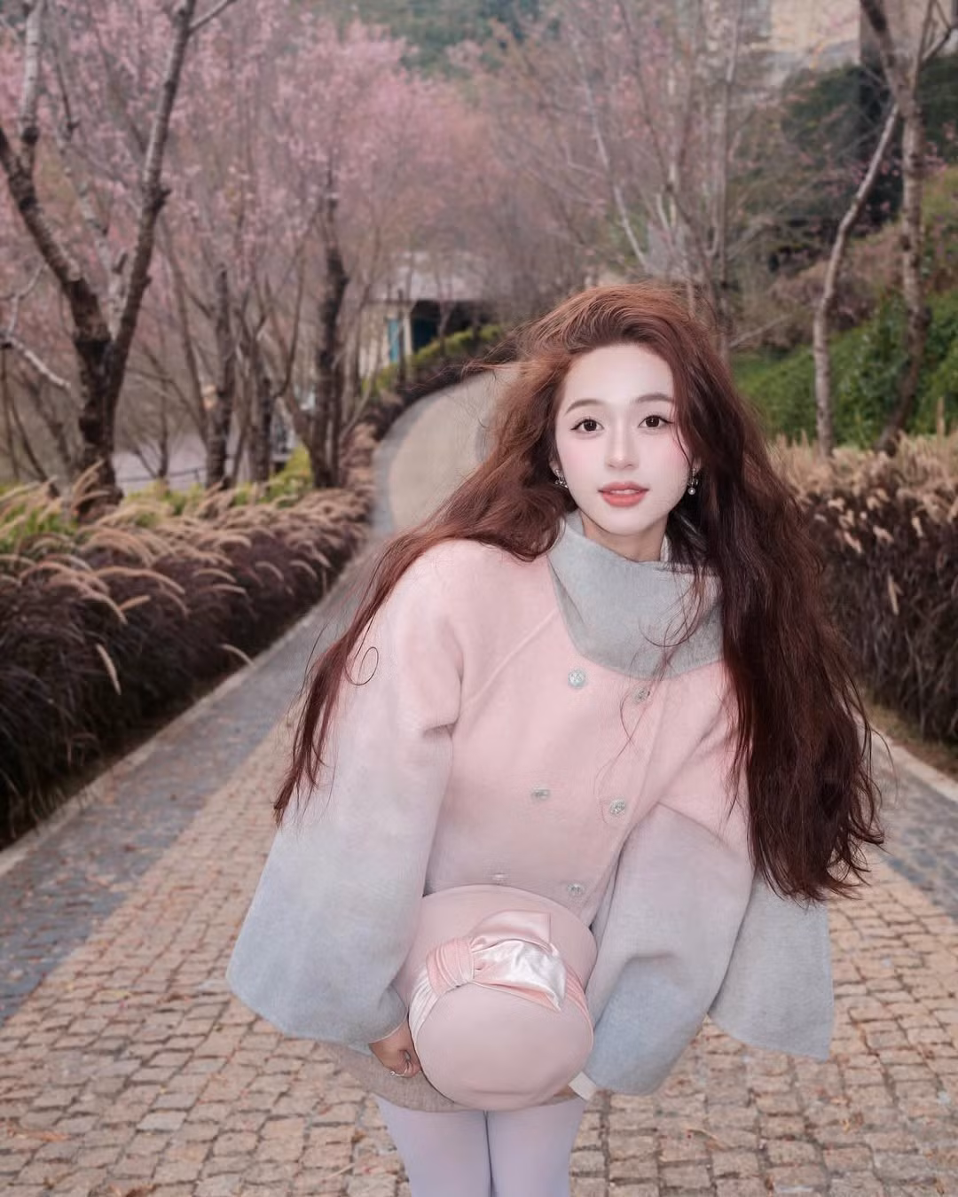 Giữa rừng mai anh đào hồng rực, Karty Chang khéo léo chọn bộ trang phục tông màu sáng kết hợp giữa trắng tinh khôi và hồng pastel, giúp tôn lên làn da trắng sứ và vóc dáng mảnh mai. (Ảnh: FBNV)