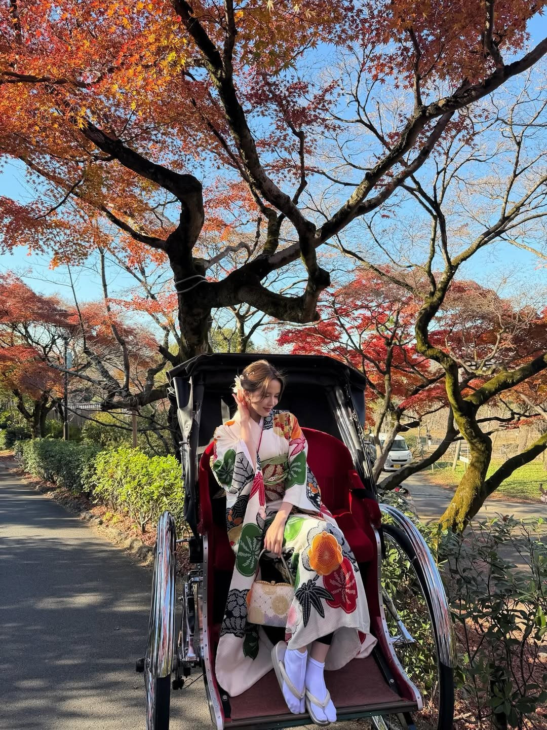 Chiếc túi xách tay nhỏ xinh với hoa văn truyền thống cùng chiếc quạt giấy là những điểm nhấn hoàn hảo, giúp tổng thể trở nên sinh động và đậm chất văn hóa. (Ảnh: IGNV)