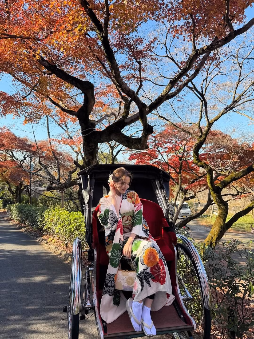 Chiếc túi xách tay nhỏ xinh với hoa văn truyền thống cùng chiếc quạt giấy là những điểm nhấn hoàn hảo, giúp tổng thể trở nên sinh động và đậm chất văn hóa. (Ảnh: IGNV)