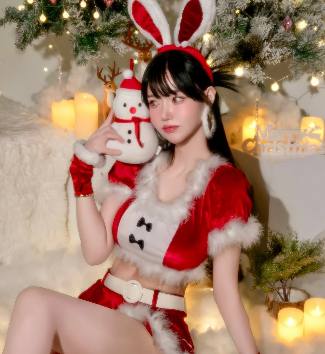 Người đẹp diện trang phục với màu đỏ và trắng chủ đạo, viền lông mềm mại, nhưng được cách điệu thành một bộ cánh ngắn, hở eo, khoe trọn đường cong cơ thể nóng bỏng. (Ảnh: @minhanna)