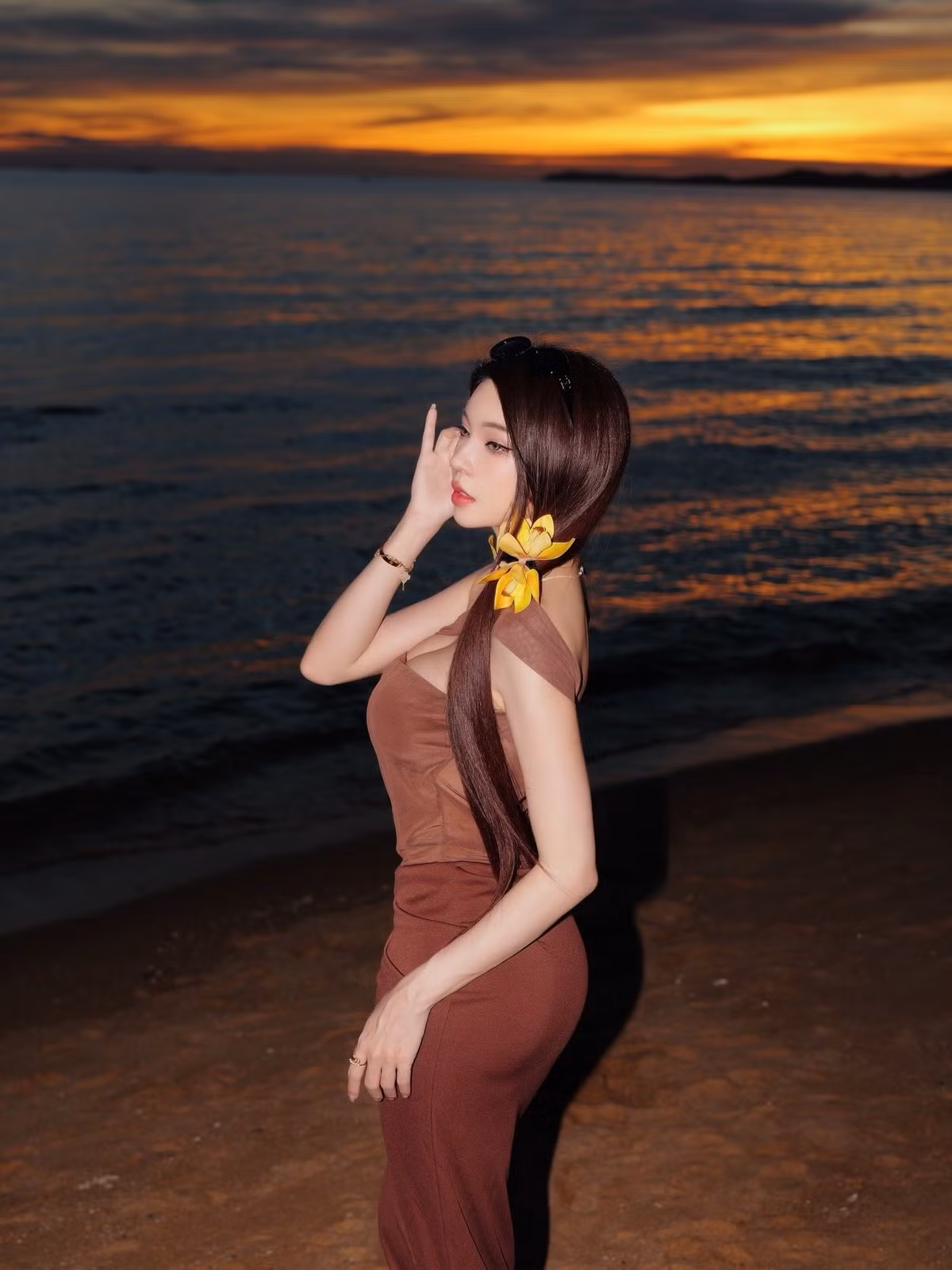 Cô nàng còn cài một bông hoa vàng rực rỡ lên tóc, làm nổi bật vẻ đẹp dịu dàng nhưng không kém phần cuốn hút dưới ánh hoàng hôn. (Ảnh: Facebook Janet Kanokwan Saesim)