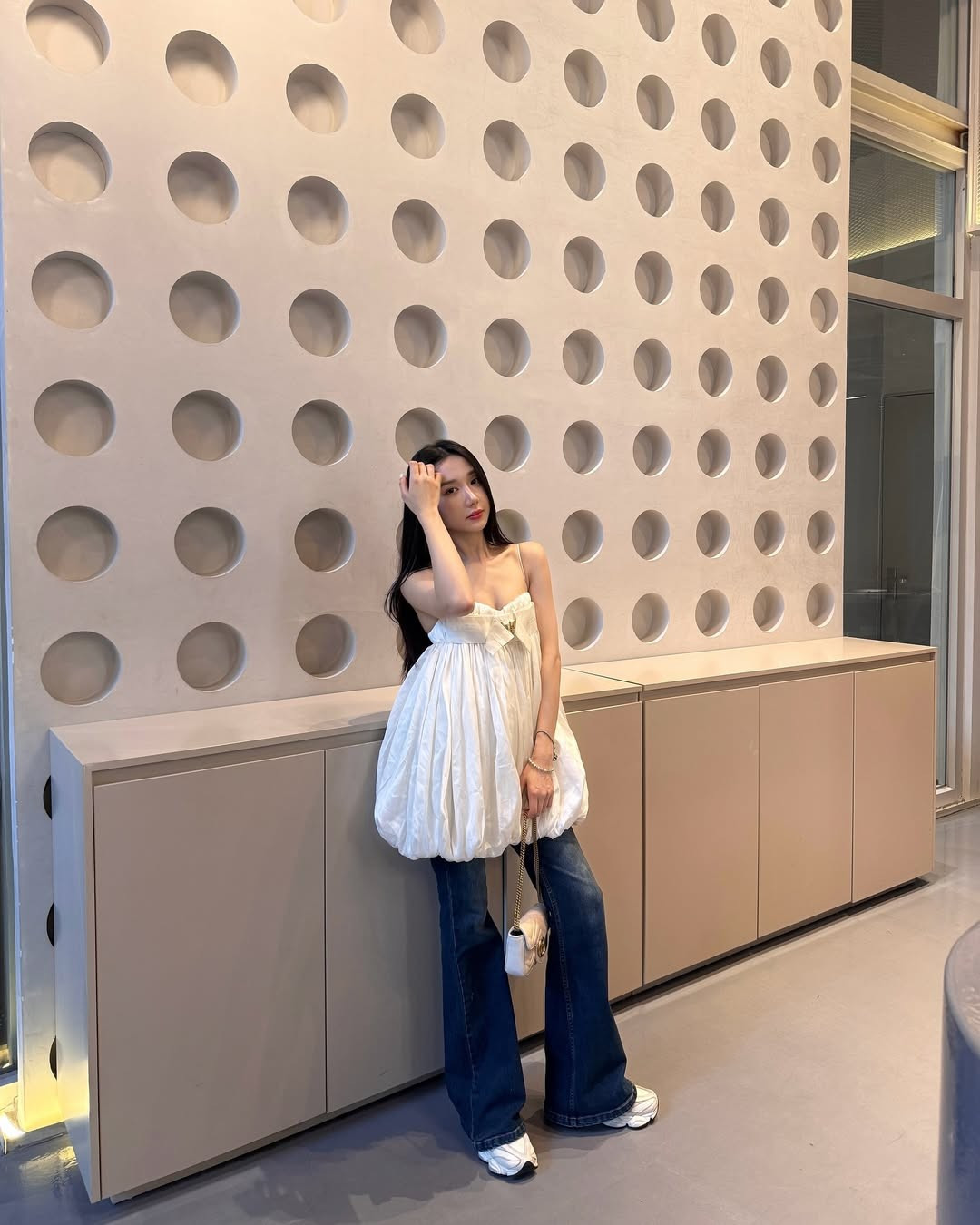 Mina hoàn thiện tổng thể bằng phụ kiện đơn giản như túi xách mini trắng, giày thể thao trắng năng động và mái tóc dài xõa tự nhiên.