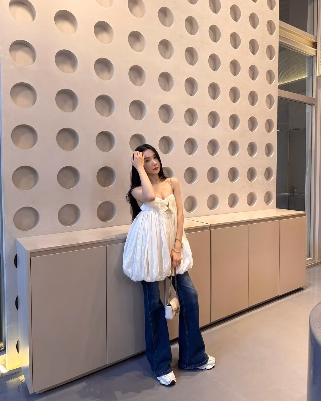 Mina hoàn thiện tổng thể bằng phụ kiện đơn giản như túi xách mini trắng, giày thể thao trắng năng động và mái tóc dài xõa tự nhiên.