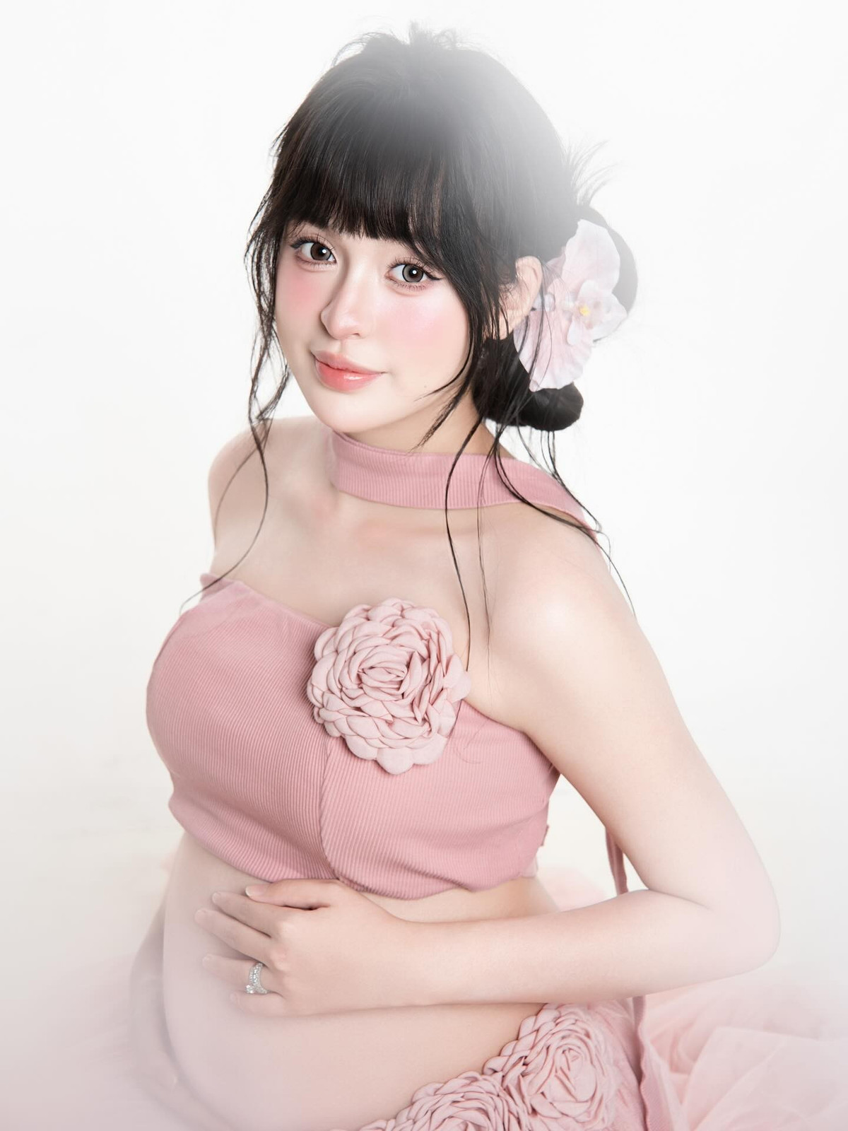 Nhan sắc của Trần Thanh Tâm trong bộ ảnh đầy rạng rỡ và tràn đầy sức sống. Với mái tóc đen búi cao, điểm xuyết hoa lụa và lối trang điểm trong trẻo, cô toát lên vẻ đẹp ngọt ngào và hạnh phúc của một người sắp làm mẹ. (Ảnh: Instagram @po.trann)