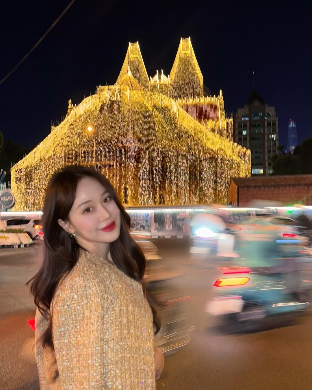 Chiếc túi Chanel classic ô trám đen làm điểm nhấn đắt giá cho tổng thể trang phục. Lối trang điểm trong trẻo với son môi đỏ giúp khuôn mặt bừng sáng giữa khung cảnh đêm. (Ảnh: IG @luusuebeauty)