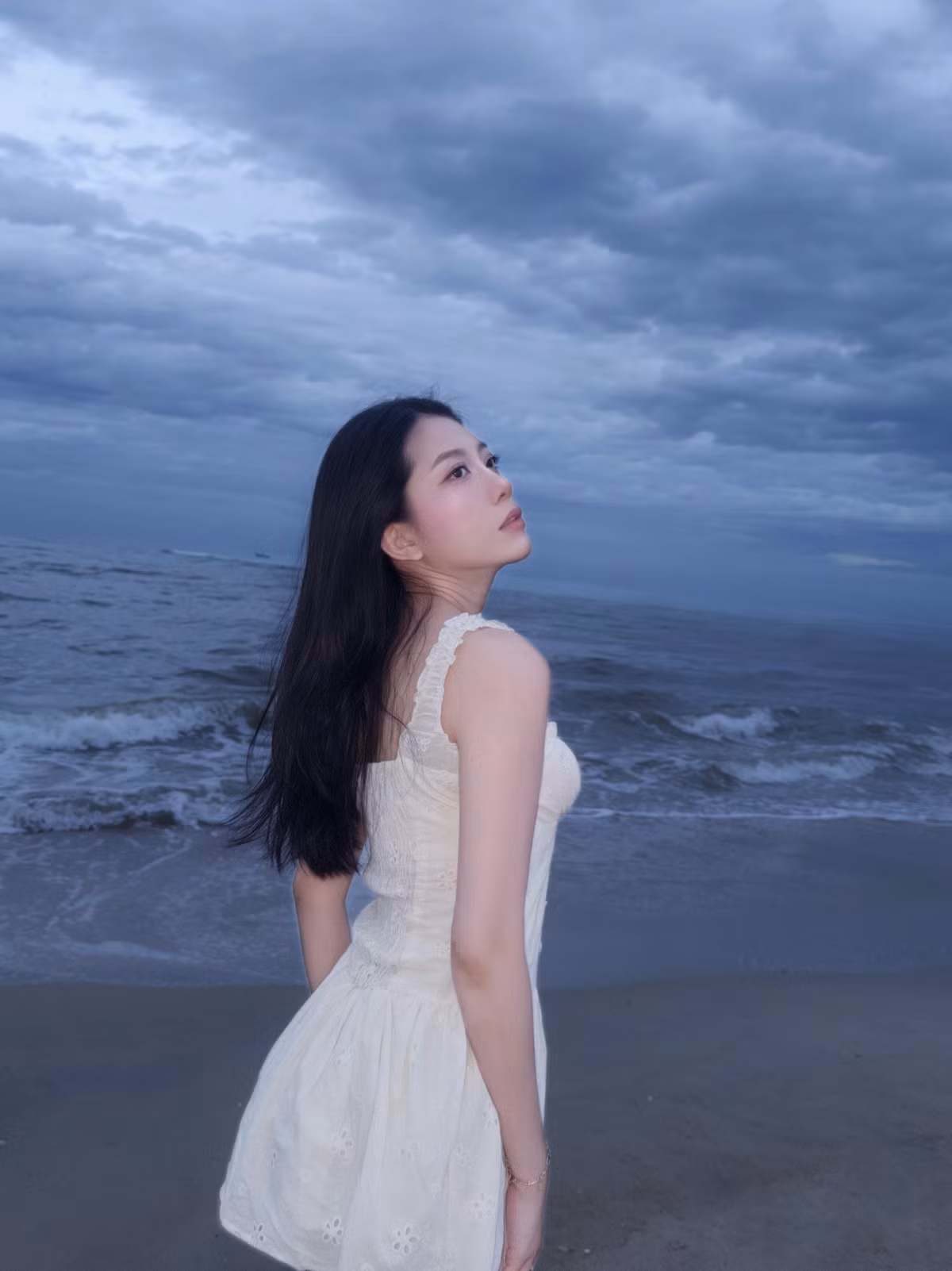 Mái tóc đen dài buông xõa tự nhiên, làn da trắng mịn cùng đôi mắt trong veo của Phương Dung càng làm nổi bật vẻ đẹp mong manh, thuần khiết.