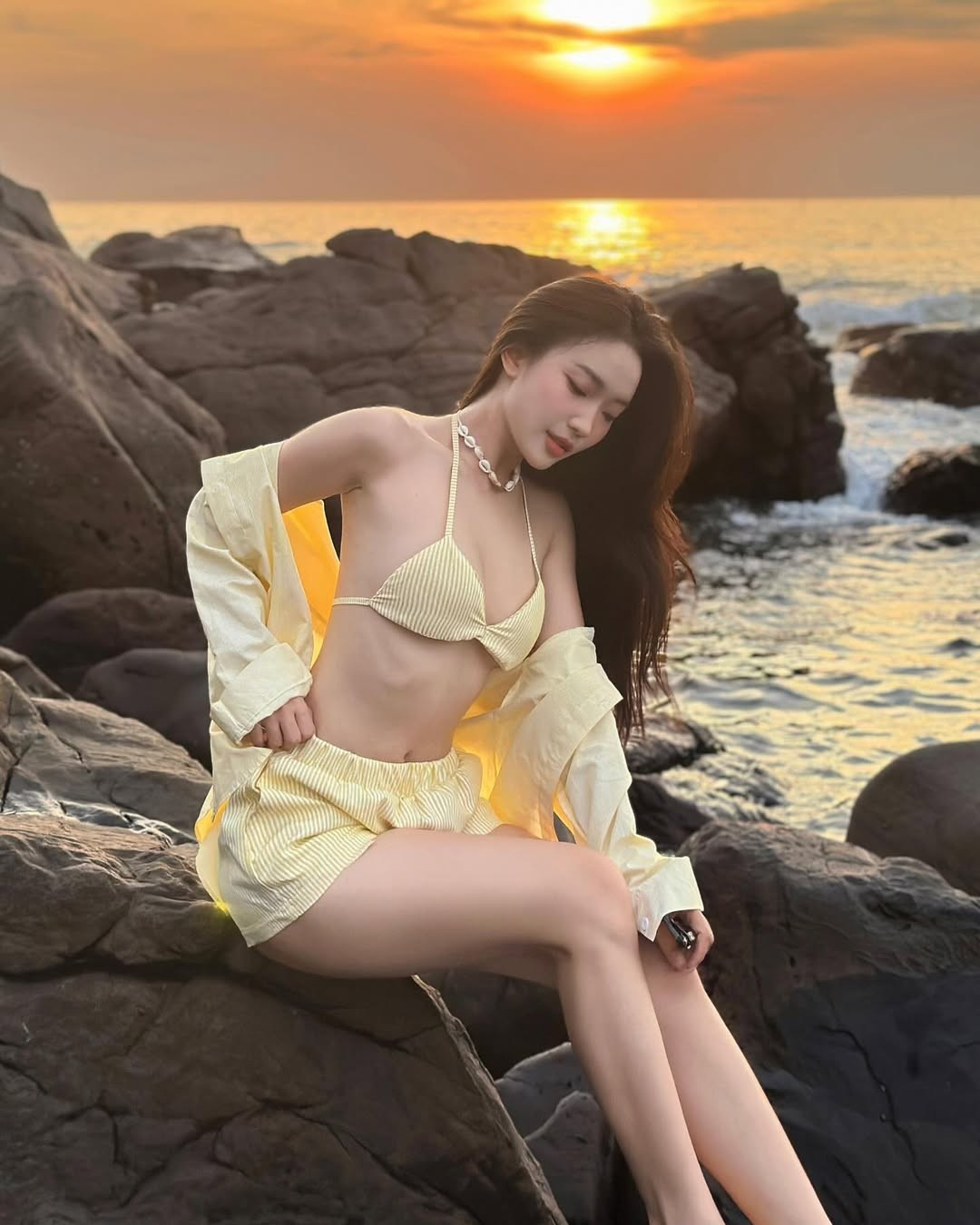 Chiếc áo sơ mi mỏng khoác hờ hững không chỉ tạo thêm lớp layer phong cách mà còn mang đến sự phóng khoáng, tự do của những chuyến đi biển mùa hè. Vẻ đẹp tự nhiên, rạng rỡ của Huệ Chi trong trang phục này đã hoàn toàn chinh phục trái tim người hâm mộ.