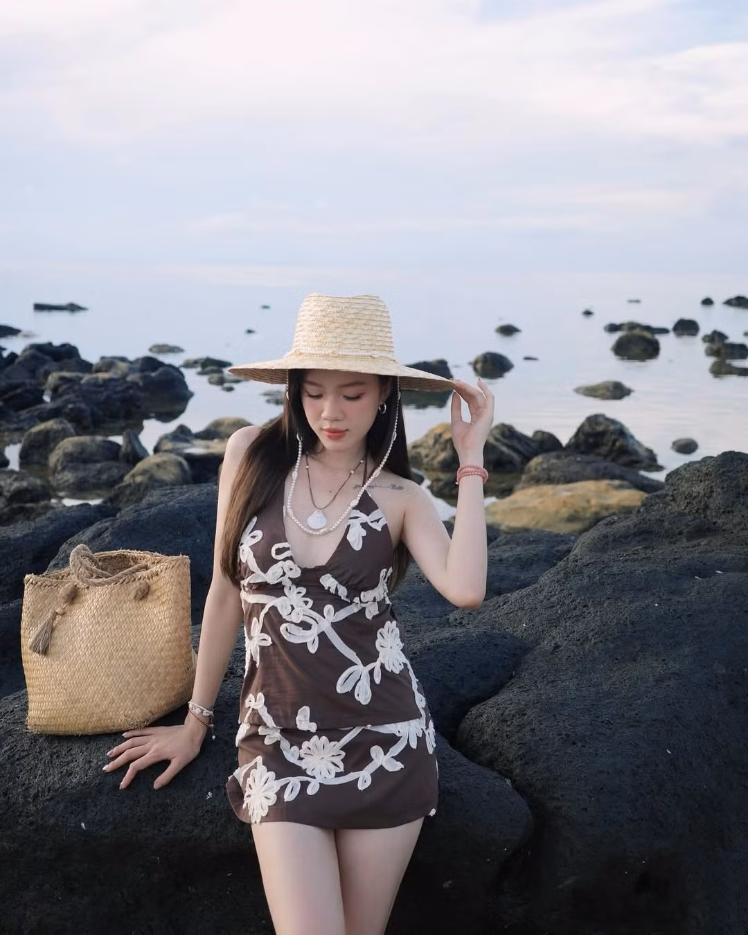 Trong một lần khác, cô nàng chọn diện một đầm mini hai dây màu nâu chocolate với họa tiết hoa trắng thêu nổi, ôm nhẹ cơ thể, vừa đủ để khoe trọn vóc dáng nuột nà nhưng vẫn giữ được vẻ thanh lịch.