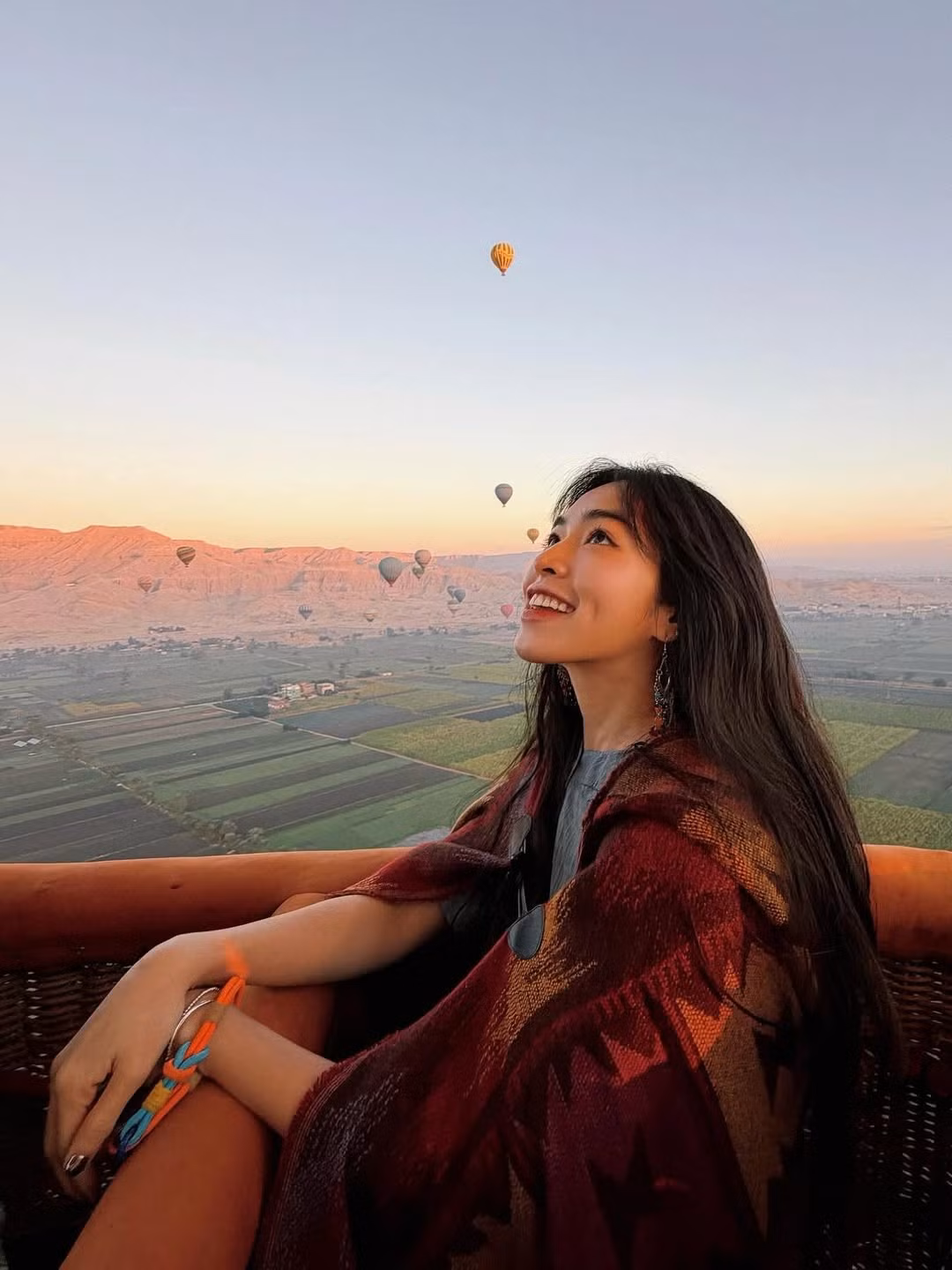 Cô nàng khéo léo chọn trang phục mang phong cách boho-chic với chiếc khăn choàng họa tiết thổ cẩm tone đỏ - nâu ấm áp, kết hợp cùng đôi khuyên mắt bản to cực kỳ ăn nhập với không gian cổ kính của vùng đất Kim tự tháp. (Ảnh: IGNV)