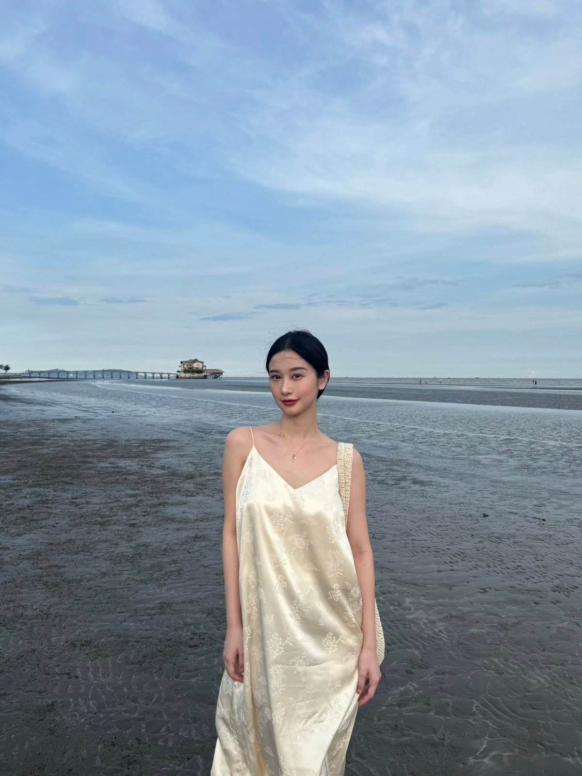 Kết hợp cùng váy là phụ kiện đơn giản nhưng cá tính: chiếc mũ lưỡi trai đồng điệu màu vàng và kính râm sành điệu. Cô nàng cũng khéo léo chọn túi tote đan len màu trắng, tạo nên tổng thể hài hòa, vừa năng động lại vừa nữ tính, rất phù hợp với không khí biển cả. (Ảnh: IGNV)