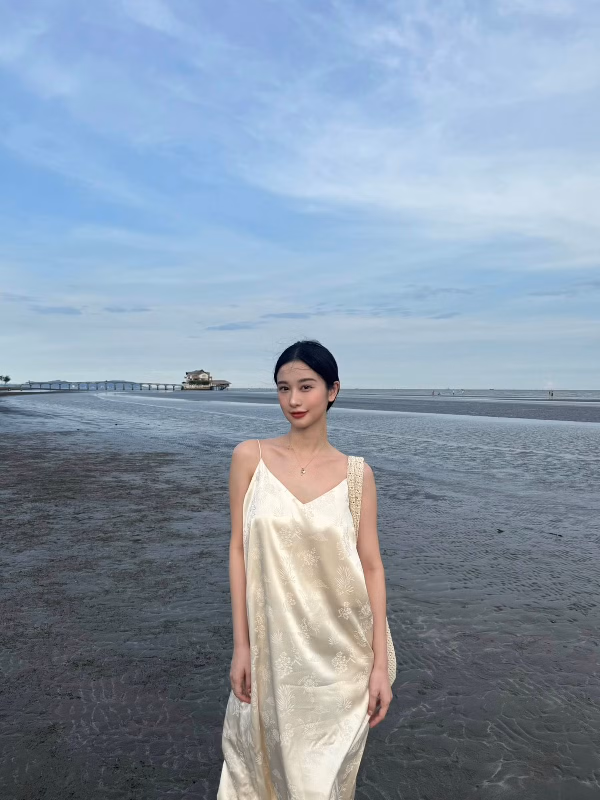 Kết hợp cùng váy là phụ kiện đơn giản nhưng cá tính: chiếc mũ lưỡi trai đồng điệu màu vàng và kính râm sành điệu. Cô nàng cũng khéo léo chọn túi tote đan len màu trắng, tạo nên tổng thể hài hòa, vừa năng động lại vừa nữ tính, rất phù hợp với không khí biển cả. (Ảnh: IGNV)